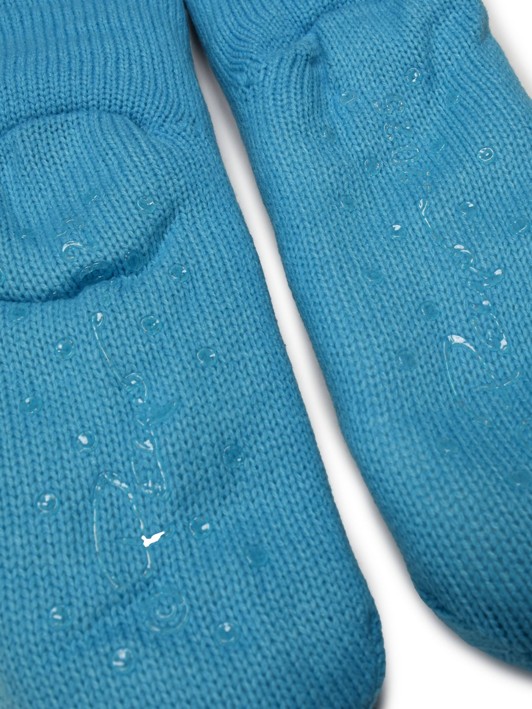 Zwei blaue gestrickte Fäustlinge mit Wassertropfen auf weißem Hintergrund.