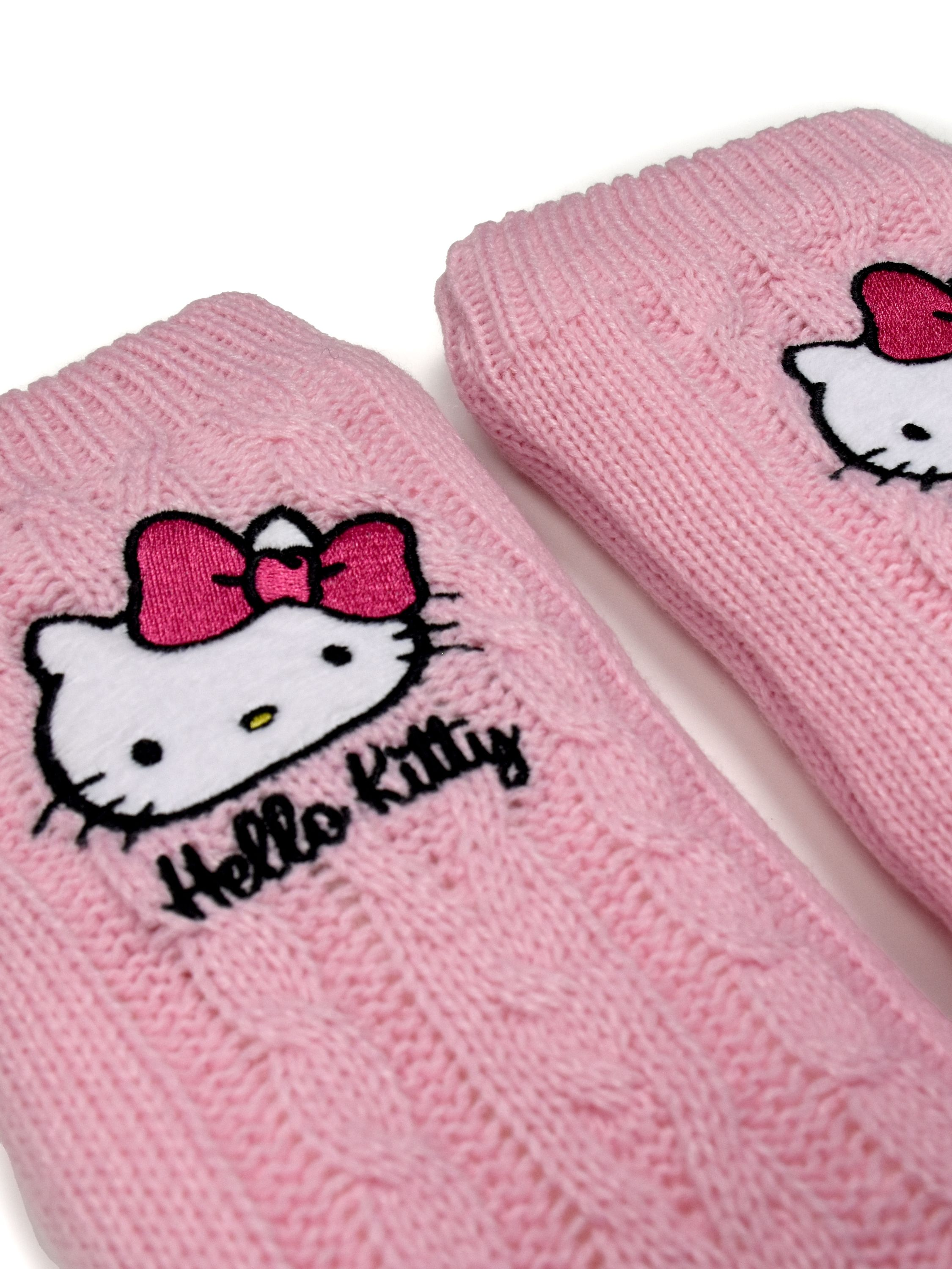 Rosa gestrickte Socken mit Hello Kitty Gesicht und Schleifen Detail. Weißer Hintergrund.