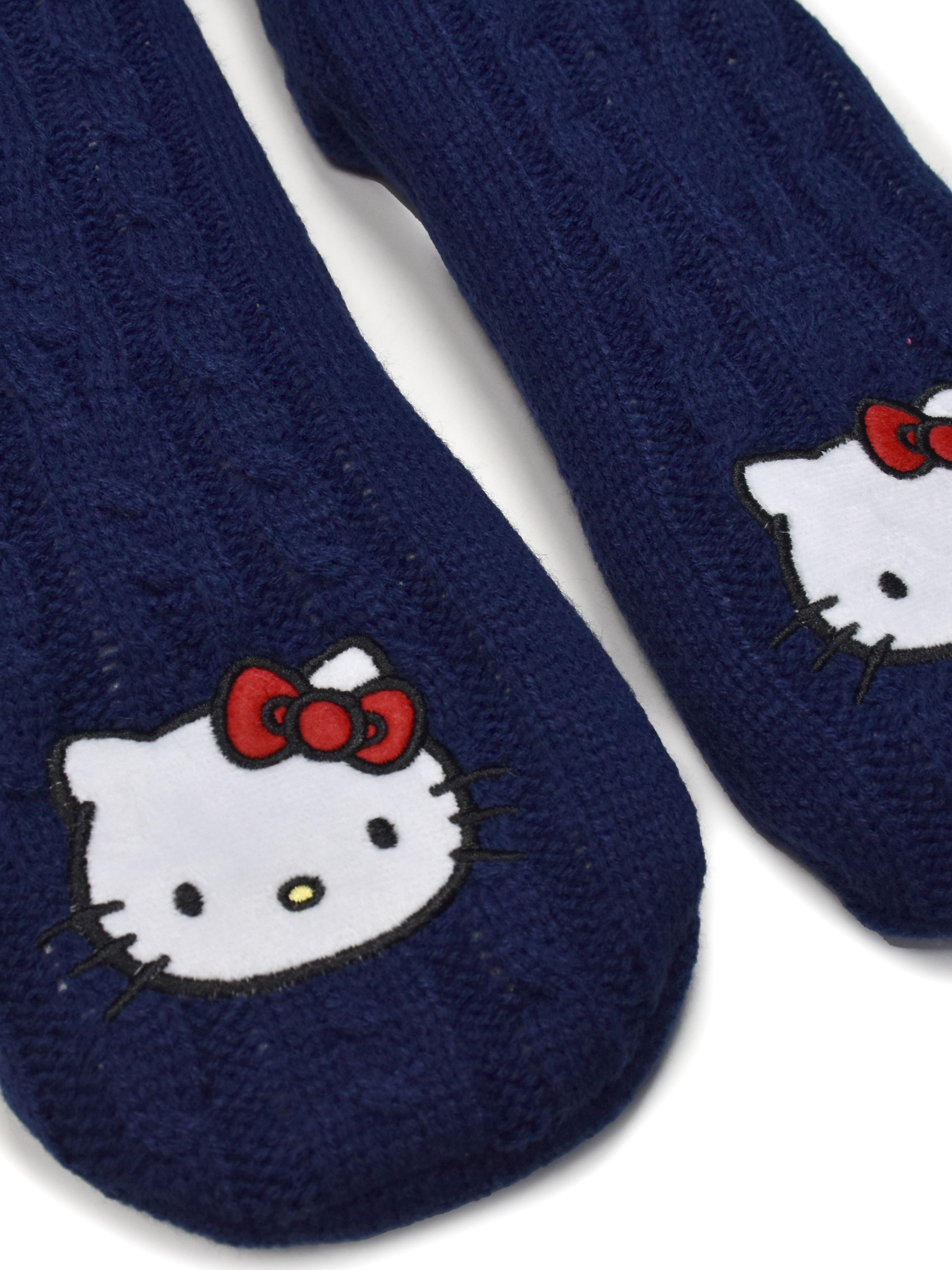 Zwei marineblaue Stricksocken mit Hello Kitty-Gesichtern. Jede hat ein weißes Gesicht, eine rote Schleife und schwarze Details.
