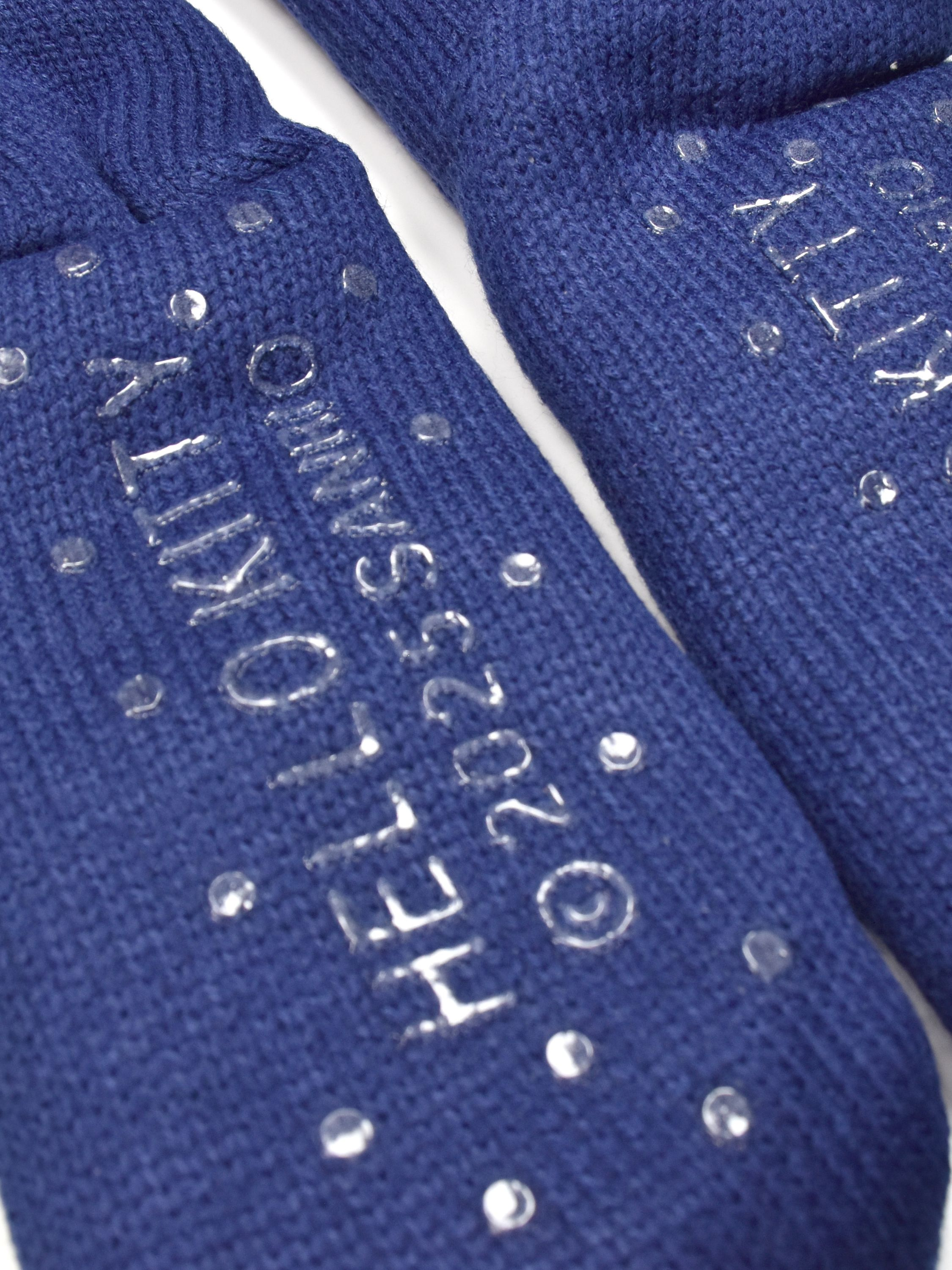 Nahaufnahme von blauen Socken, Hello Kitty-Logo und ©2023 Sanrio. Klare, runde Verzierungen sind verstreut.