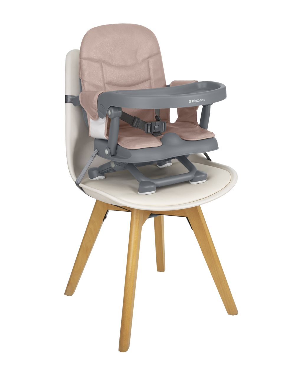 Ein Babyhochstuhl steht auf einem Holzstuhl. Der Babyhochstuhl ist grau und rosa. Der Holzstuhl ist weiß mit Holzbeinen.