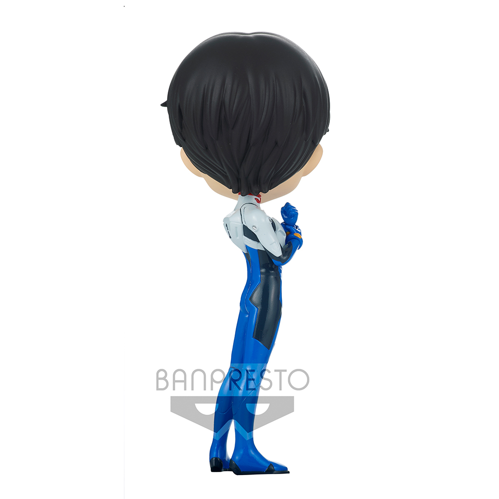Una statuetta di una persona con i capelli neri, che indossa un abito blu e bianco. La persona guarda in basso. Lo sfondo è bianco.