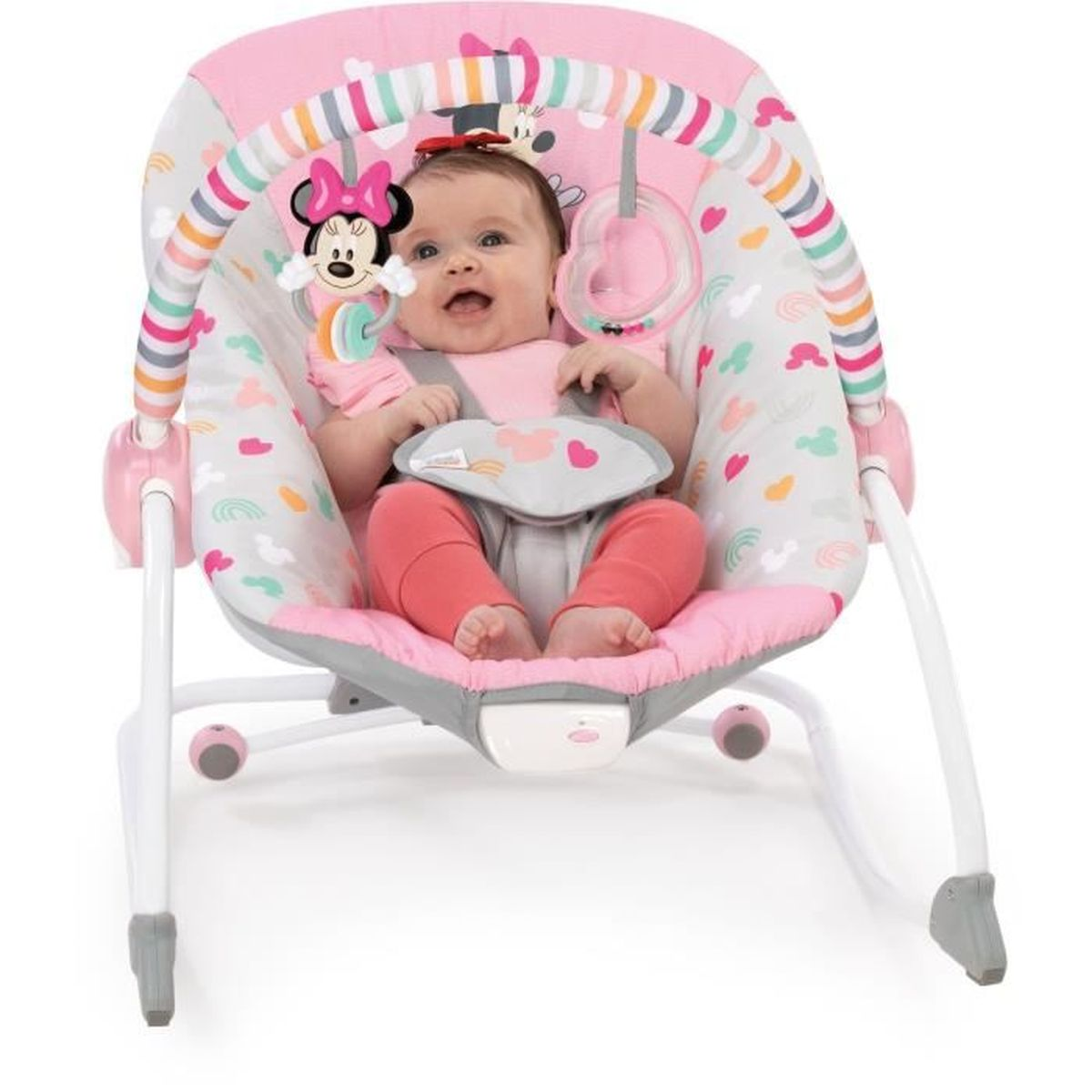 Ein Baby in einer Wippe im Minnie-Maus-Design. Die Wippe ist rosa und grau. Das Baby lächelt und trägt Pink und Rot.