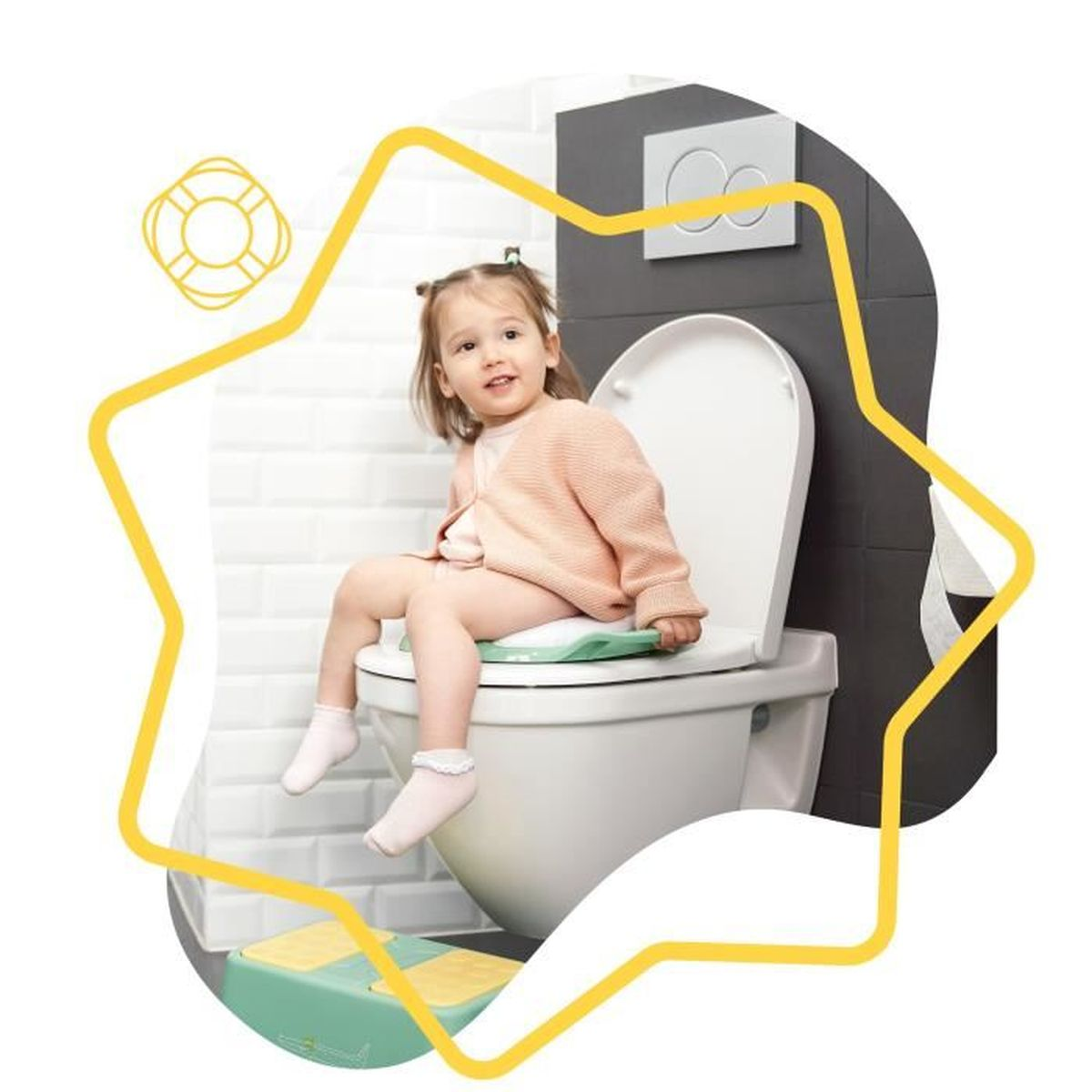 Ein Kleinkind sitzt auf einer Toilette mit grünem Sitz. Sie trägt einen rosa Pullover und weiße Socken. Unten ist ein gelb-grüner Tritthocker.