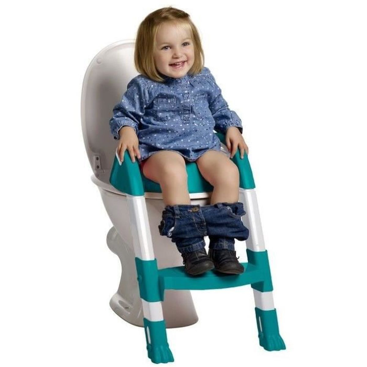 Ein lächelndes Kleinkind sitzt mit einem Tritthocker auf einer Toilette. Sie trägt ein blaues Hemd und Jeans, ihre Hose ist unten.