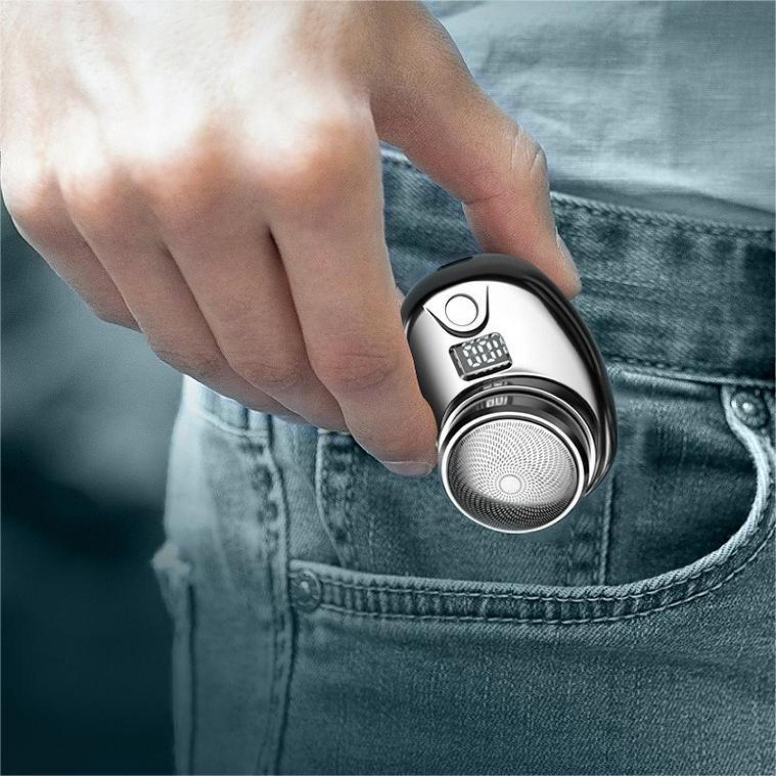 Eine Hand hält einen silber-schwarzen Rasierer vor einem Hintergrund aus Denim.
