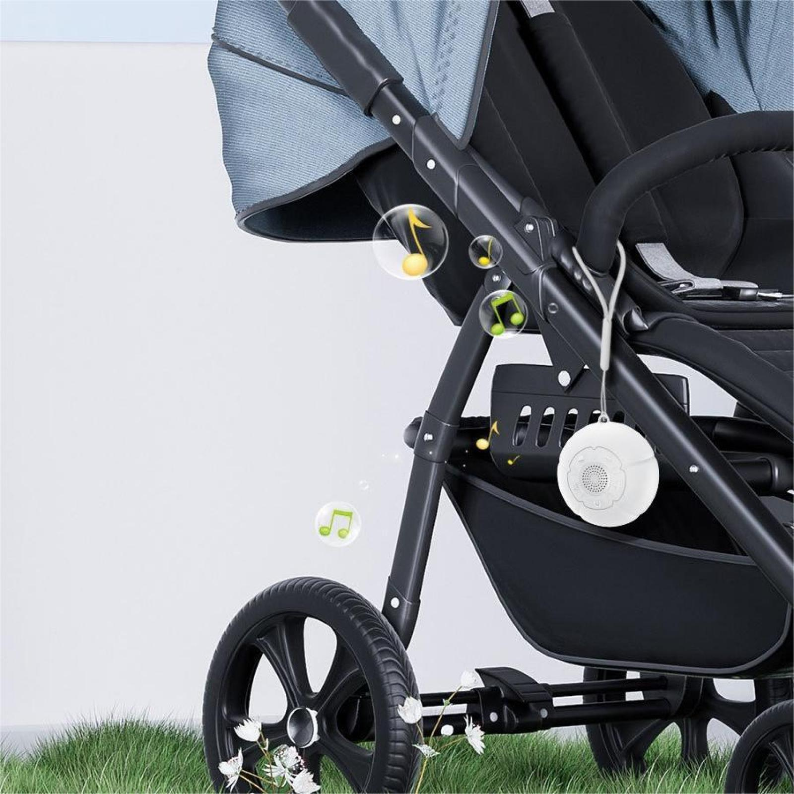 Ein Kinderwagen mit einem weißen Soundgerät. Musiknoten schweben um den Kinderwagen herum. Die Szene spielt sich im Freien ab.