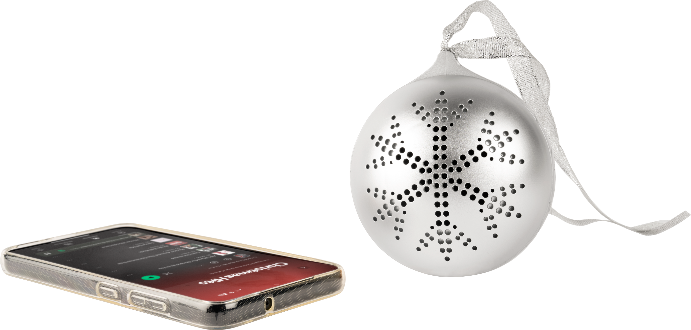Ein silberner Weihnachtsschmuck mit Schneeflockenmuster und ein Telefon, das Weihnachtsmusik abspielt. Schwarzer Hintergrund.