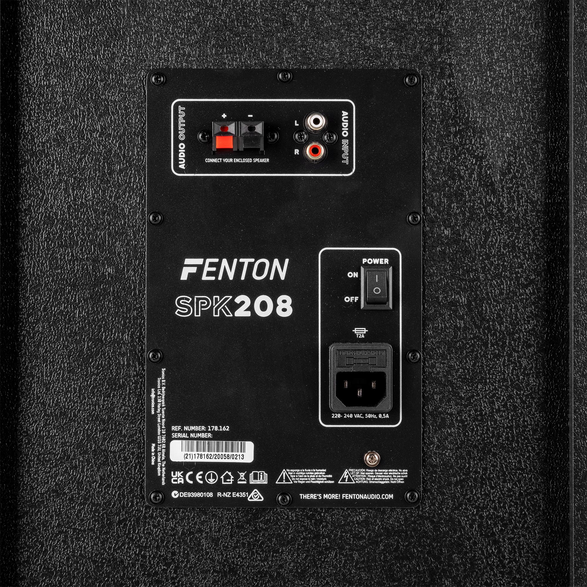 Achterpaneel van een Fenton SPK208 luidspreker. Het heeft audio-ingangen/uitgangen, een aan/uitschakelaar en een stroomingang. Zwart getextureerd oppervlak.