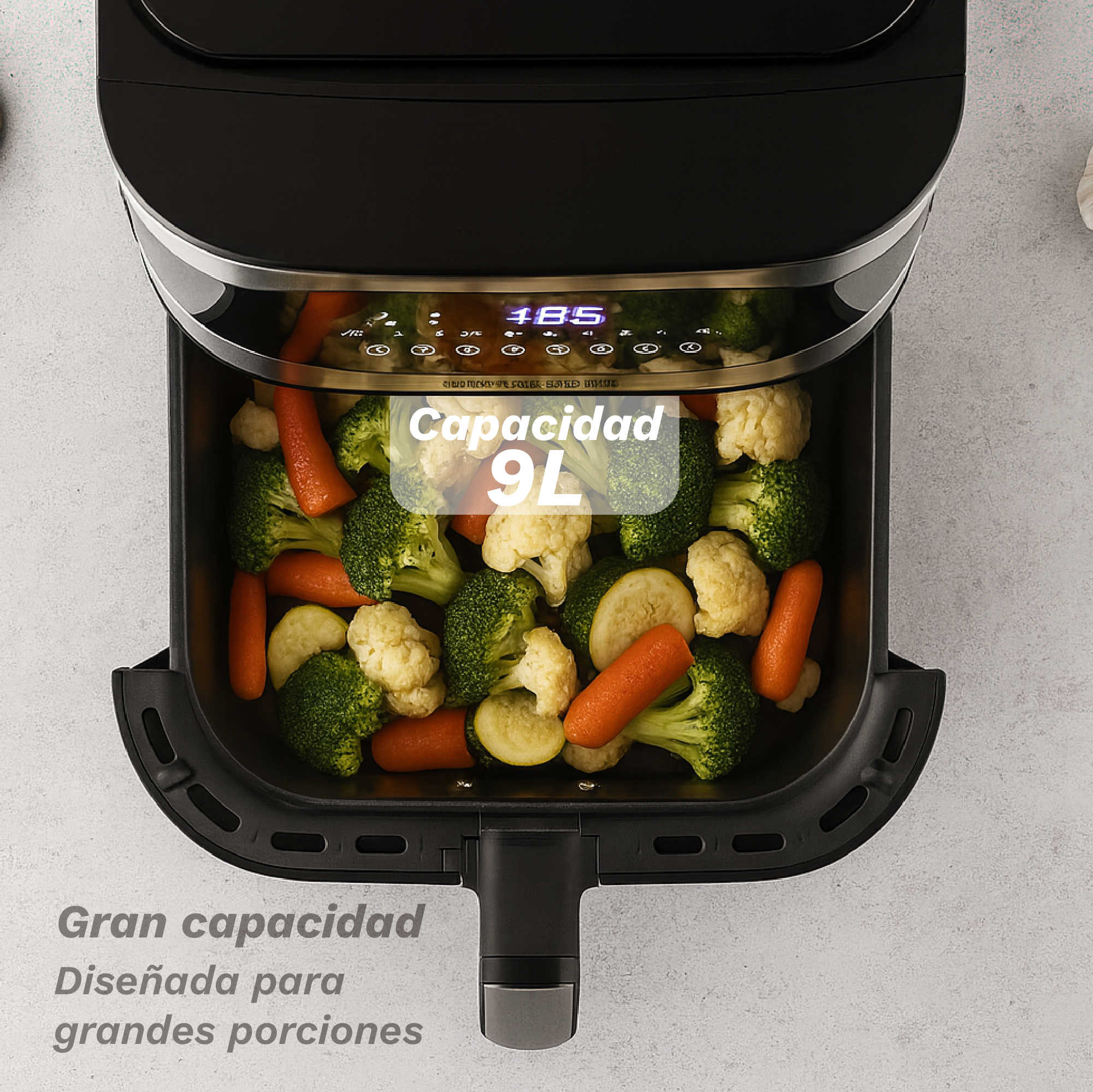 Una freidora de aire con verduras. Muestra 185 y tiene una capacidad de 9L. Se ven zanahorias, brócoli y coliflor.