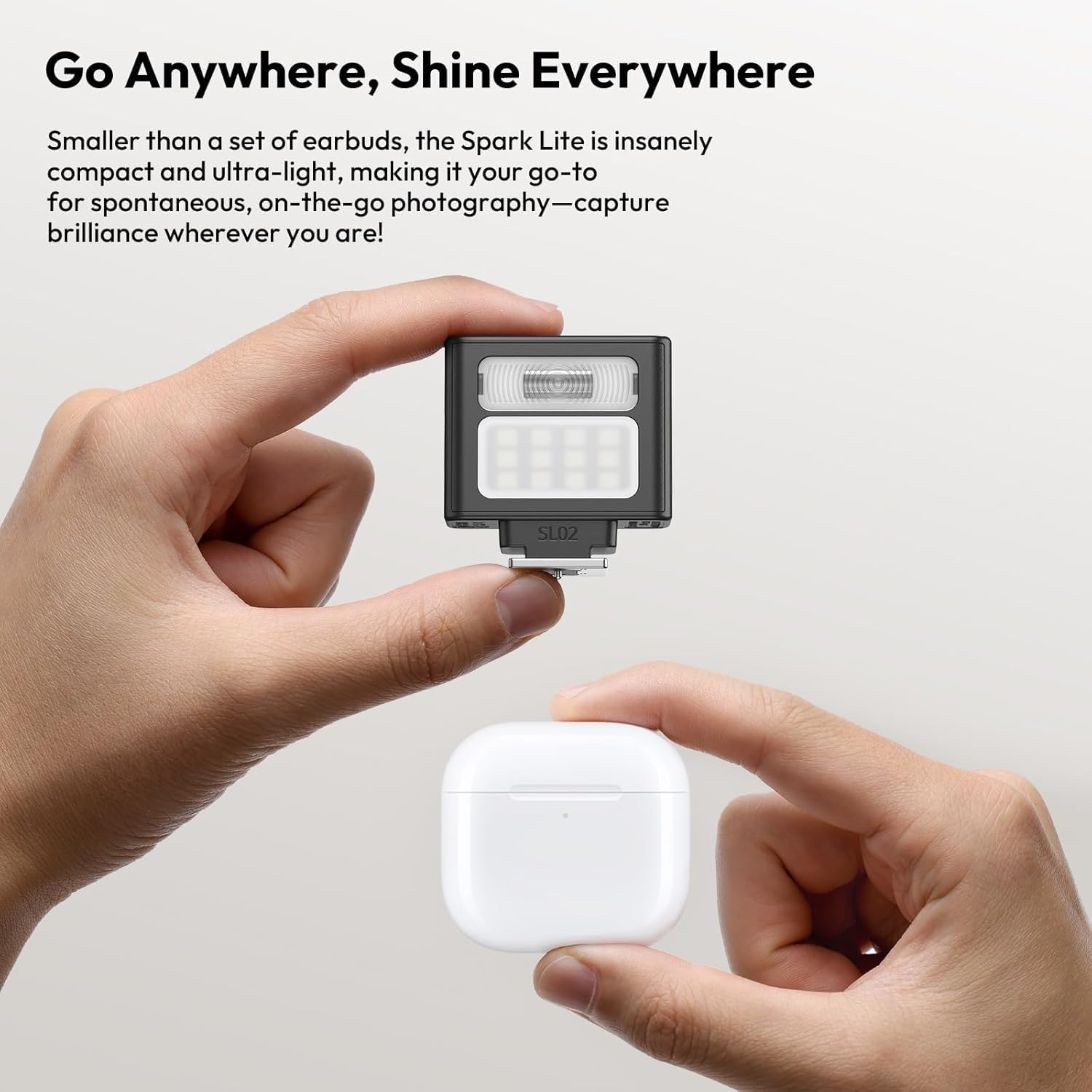 Ręce trzymające czarną lampę błyskową i białe etui na słuchawki. Tekst u góry brzmi: Idź gdziekolwiek, świeć wszędzie.