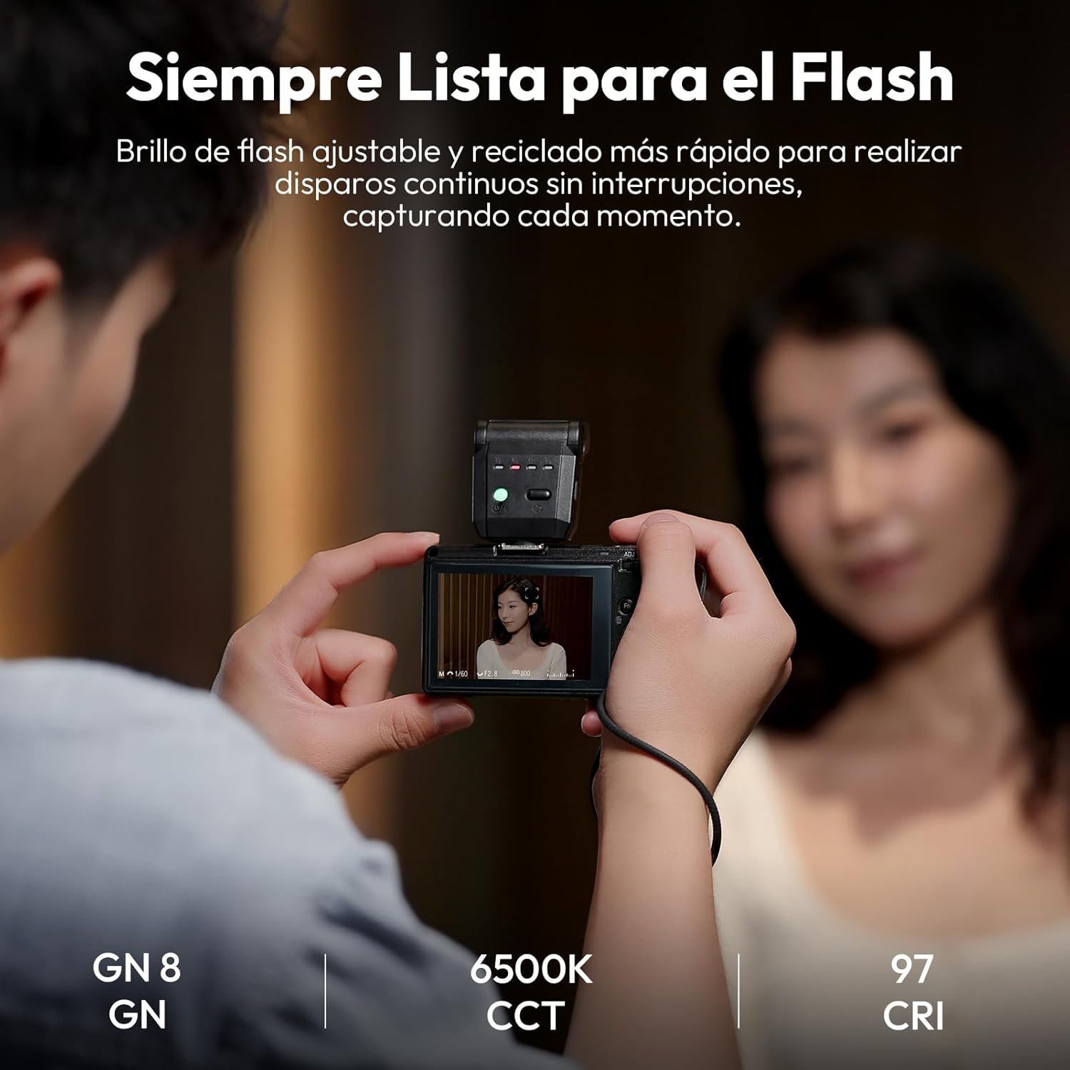 Osoba trzyma aparat z lampą błyskową, robiąc zdjęcie kobiecie. Tekst na dole wskazuje: GN 8, 6500K CCT, 97 CRI.