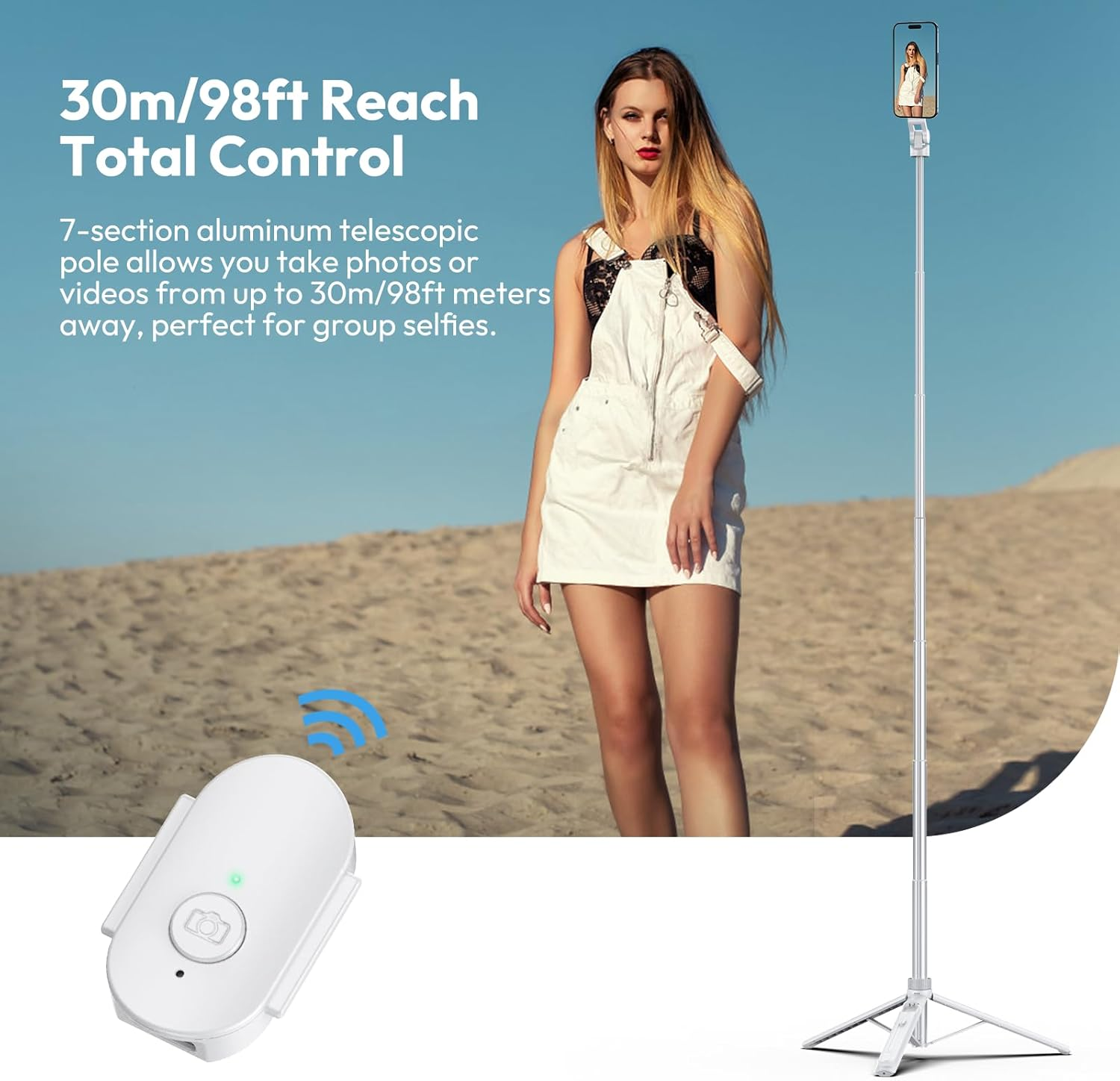 Kobieta trzyma kij do selfie z telefonem. Pilot jest na pierwszym planie. Tło przedstawia plażę i błękitne niebo.