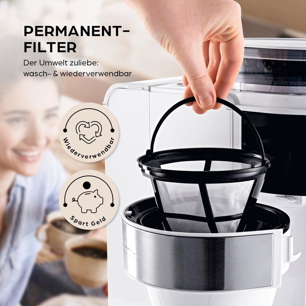 Eine Hand hält einen schwarzen Kaffeefilter über einer weißen Kaffeemaschine. Der Text lautet 'PERMANENT-FILTER' und 'wiederverwendbar'. Eine Frau lächelt im Hintergrund.