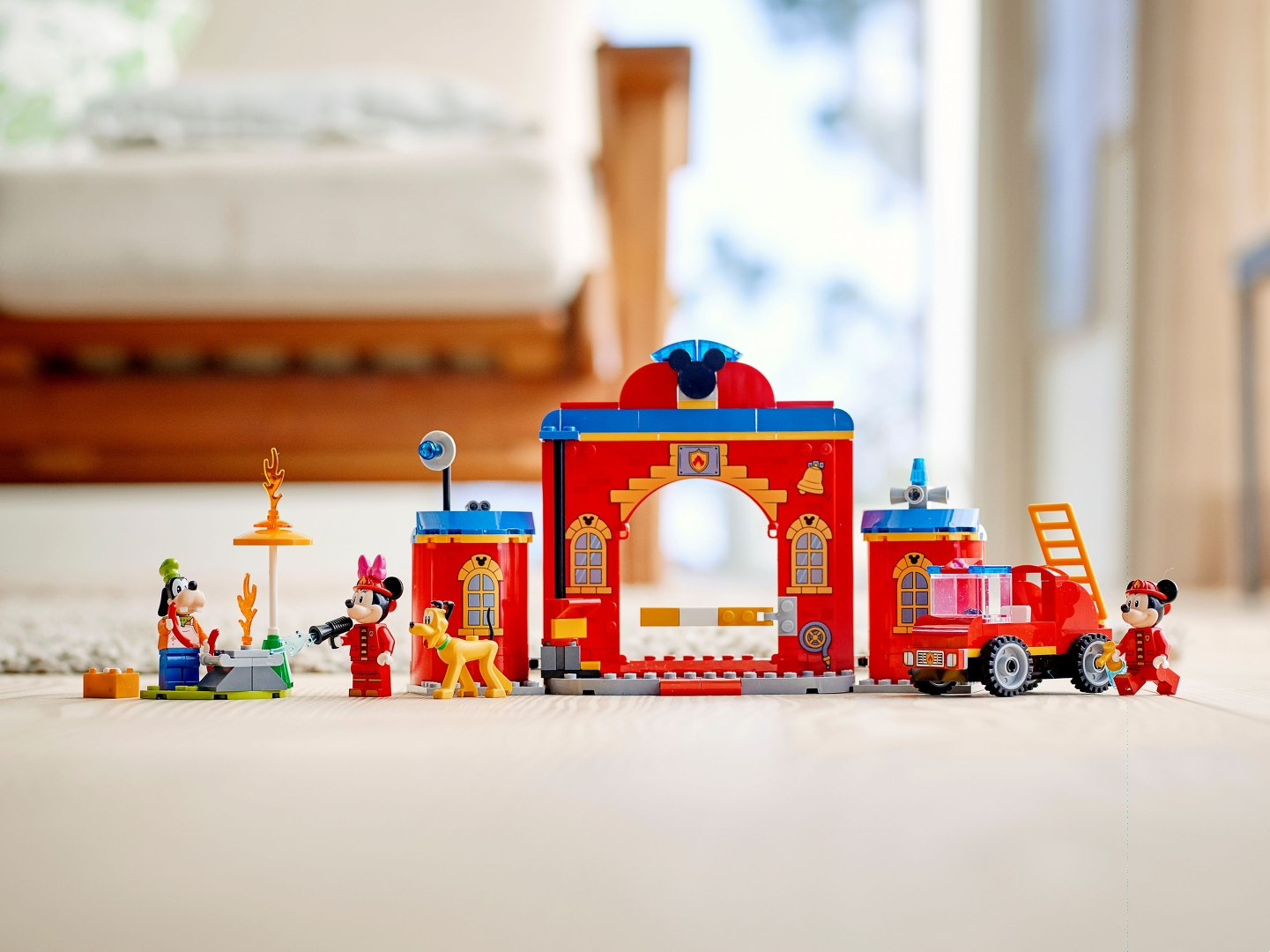 Ein Mickey-Mouse-Lego-Set mit Goofy-, Minnie- und Pluto-Figuren. Eine rote Feuerwache und ein Lastwagen sind zu sehen.