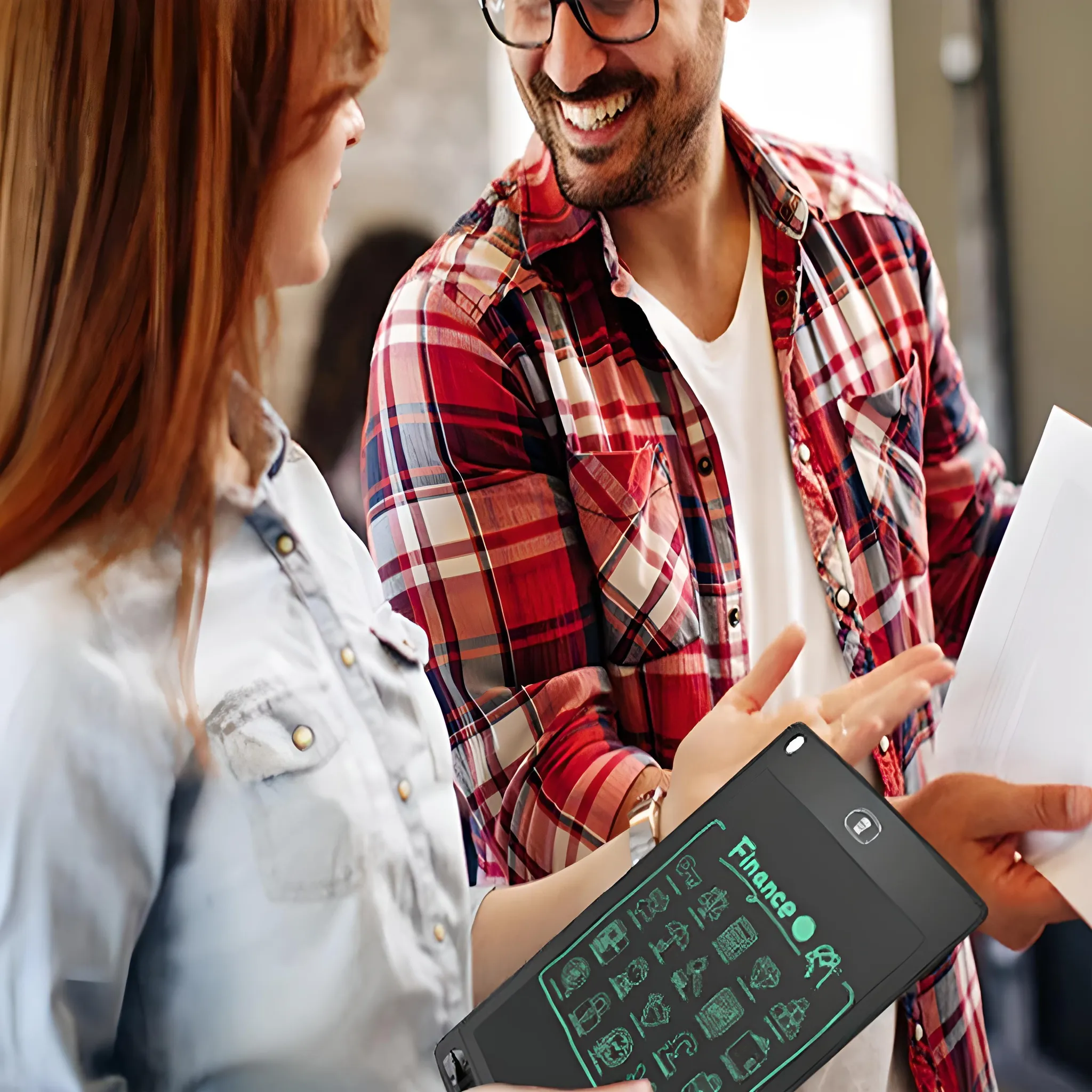 Zwei Personen diskutieren über Finanzen. Einer hält ein Tablet mit Symbolen, der andere Papiere. Mann trägt Brille und ein kariertes Hemd.