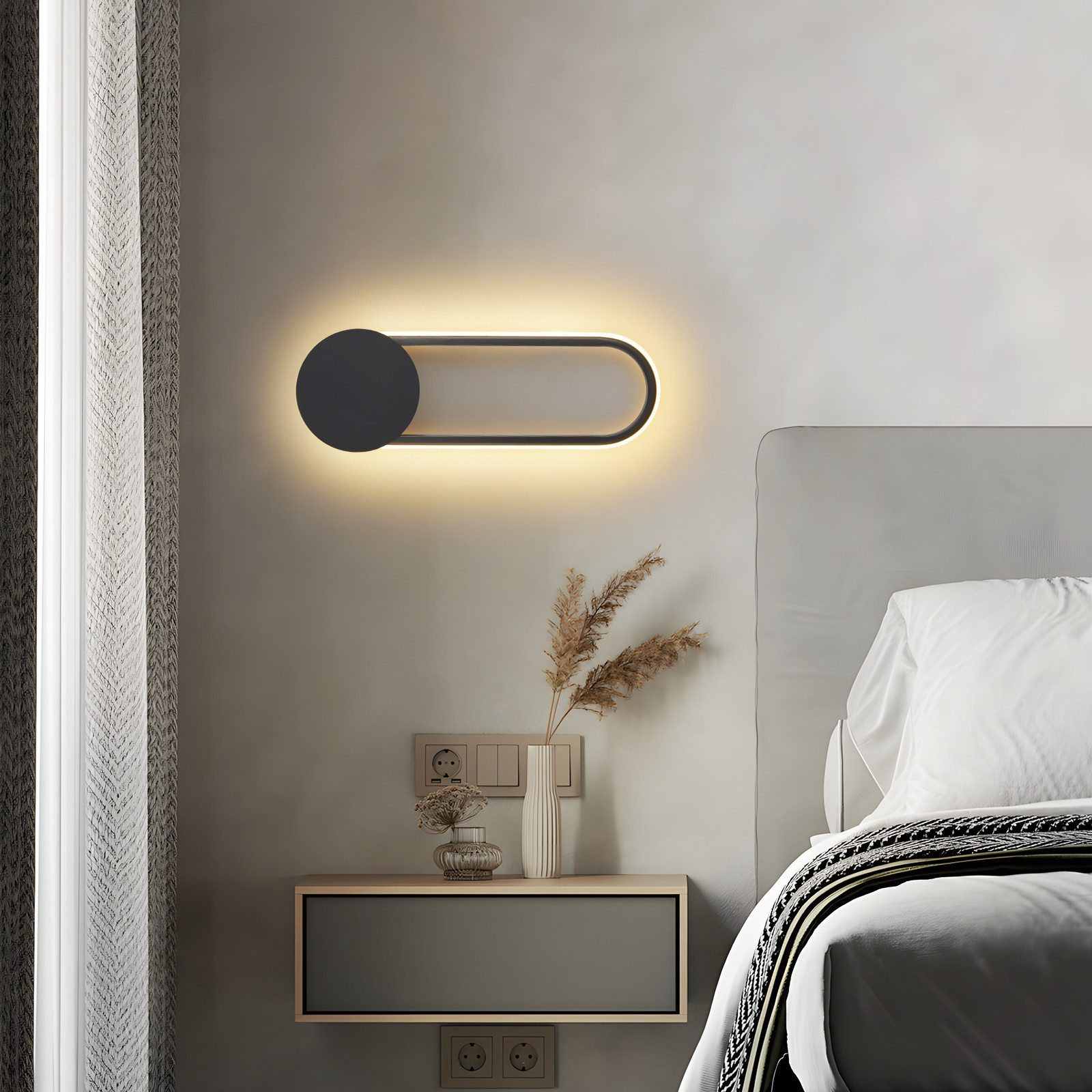 Scena di camera da letto con lampada da parete, comodino, letto e tenda. La lampada è ovale nera con luce.
