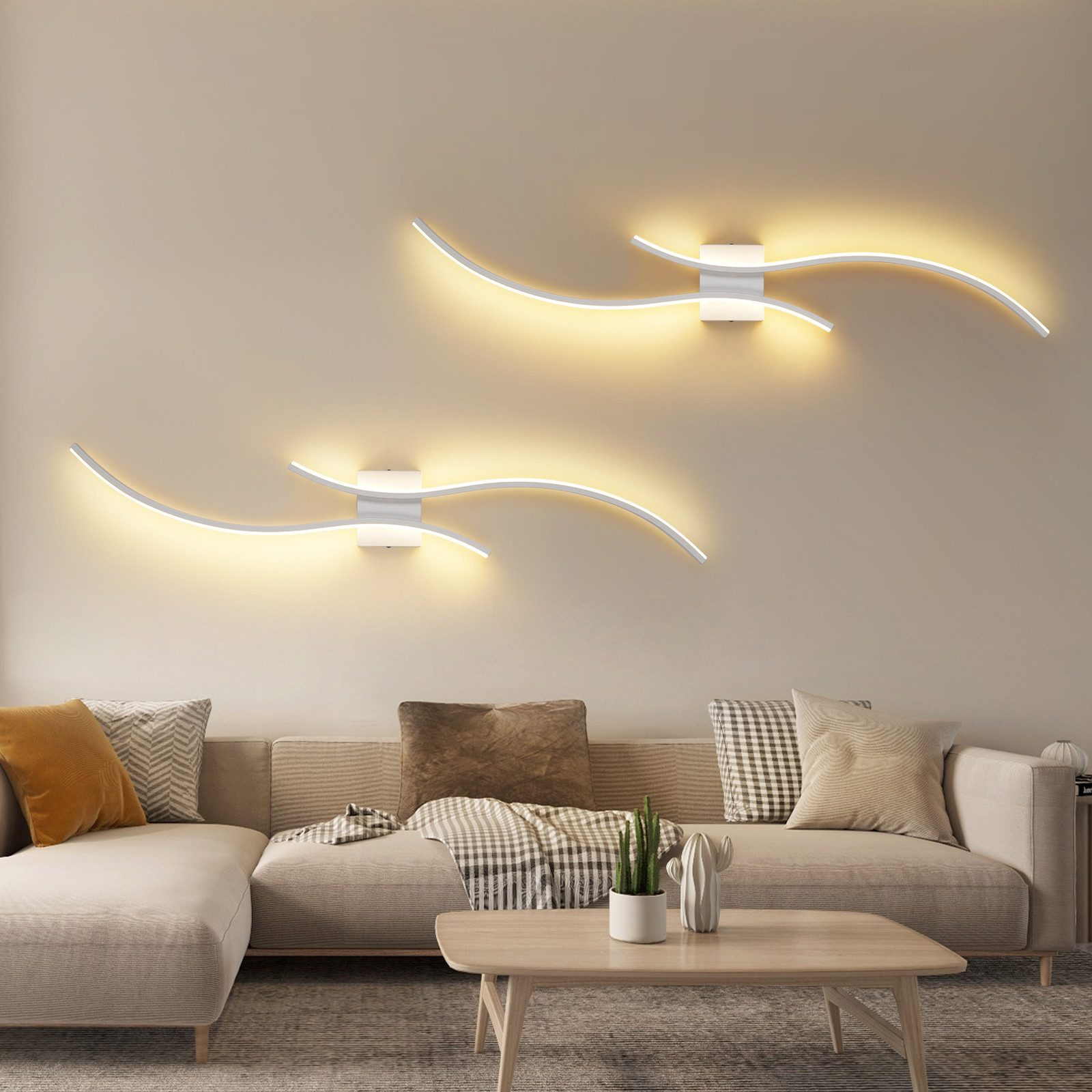 Soggiorno con divano, tavolino e applique. Muri beige, due luci moderne dal design curvo.