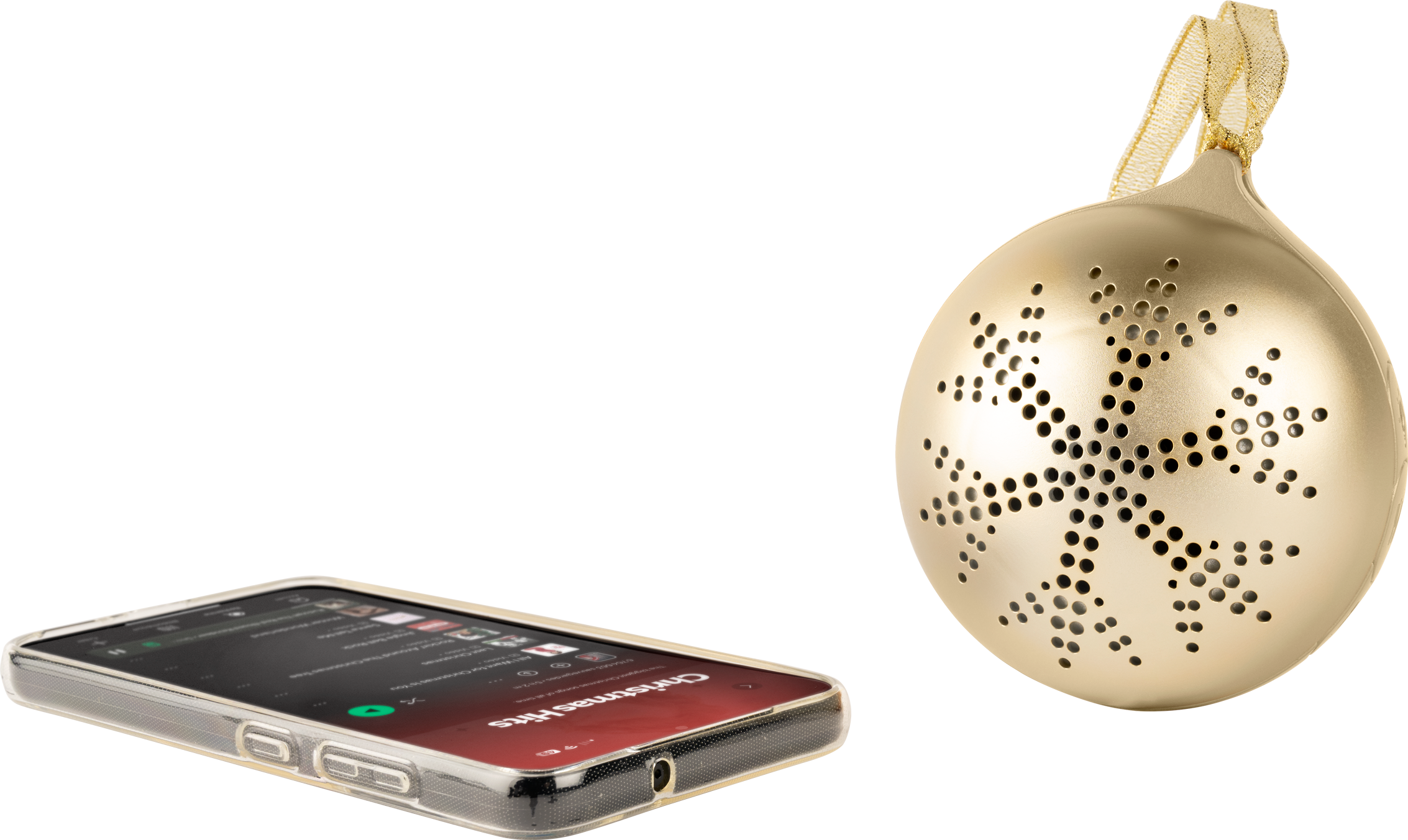 Ein goldener Weihnachtsschmuck mit Schneeflockenmuster und ein Smartphone, das Weihnachtsmusik abspielt, liegen auf einer weißen Oberfläche.