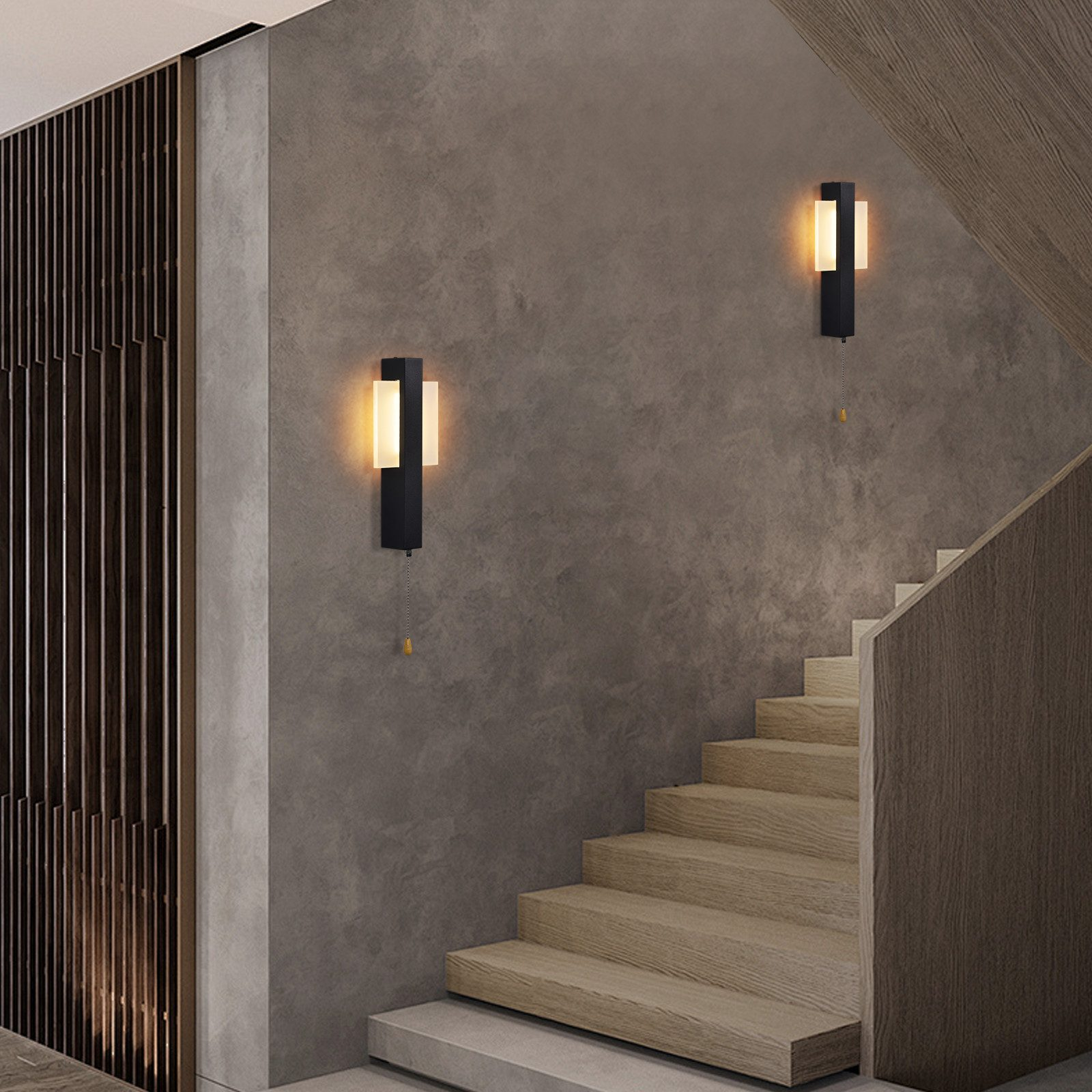 Un interno moderno con scale e lampade da parete. Le pareti sono grigie e le scale sono in legno. Due lampade da parete nere.
