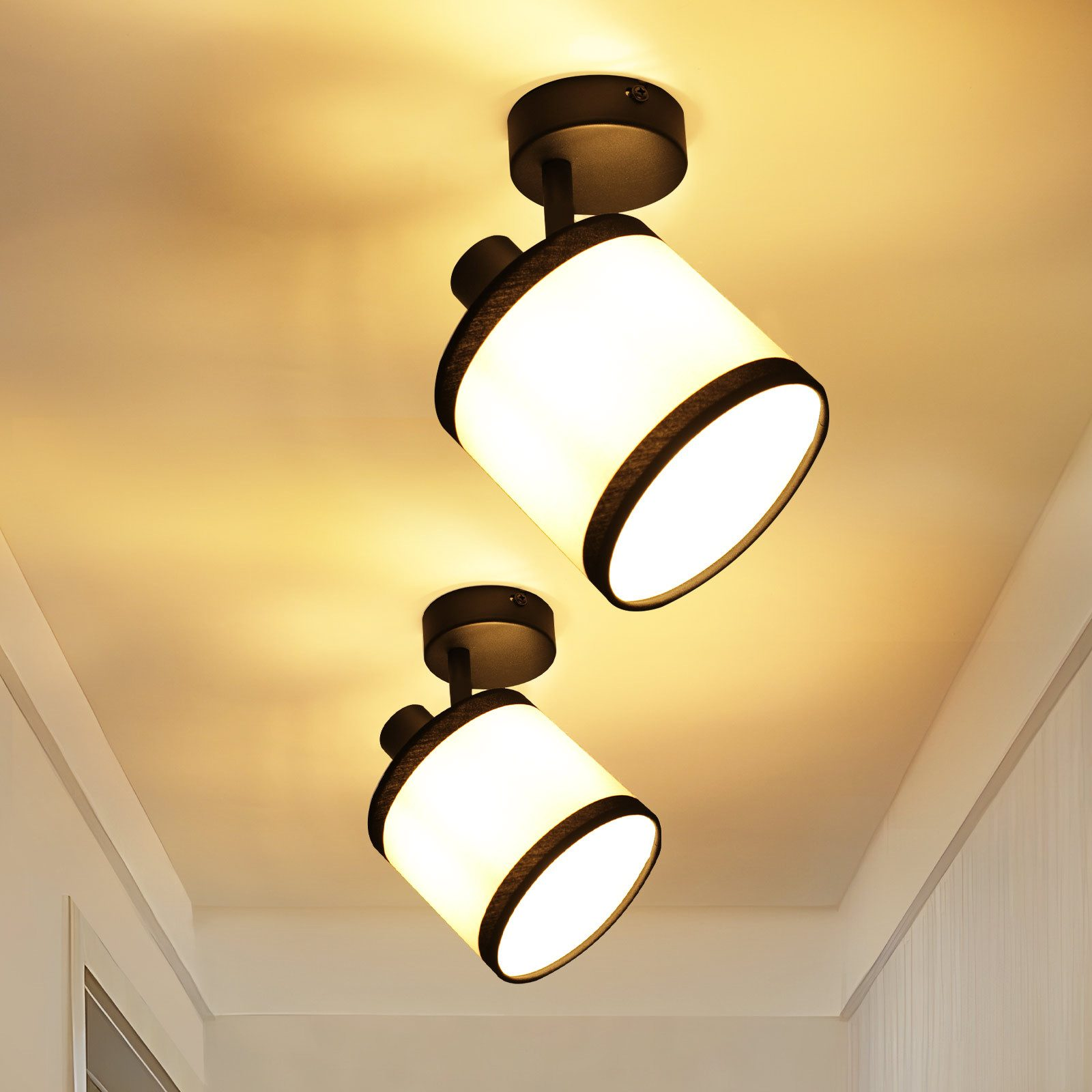 Due plafoniere con paralumi bianchi e cornici nere. Le luci sono montate su un soffitto color crema.