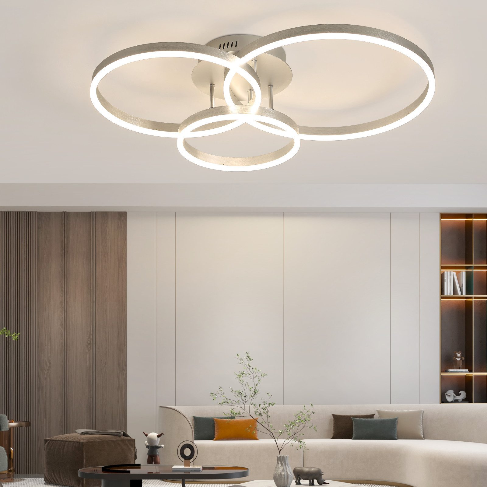 Un moderno soggiorno con una luce a soffitto unica. Si vedono un divano beige, una parete in legno e decorazioni.