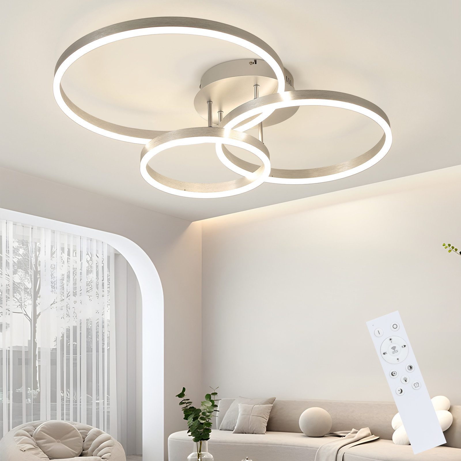Una moderna plafoniera con tre luci circolari. Un telecomando è in primo piano. Un divano è visibile sullo sfondo.