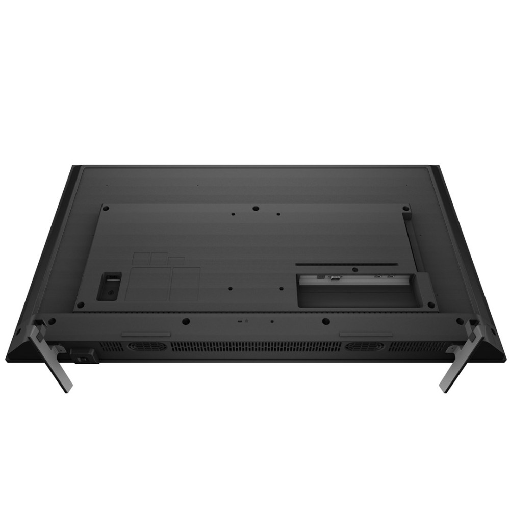 Widoczny jest tył czarnego telewizora. Dwie nóżki są wysunięte. Obecne są różne porty i otwory wentylacyjne. Powierzchnia jest teksturowana.