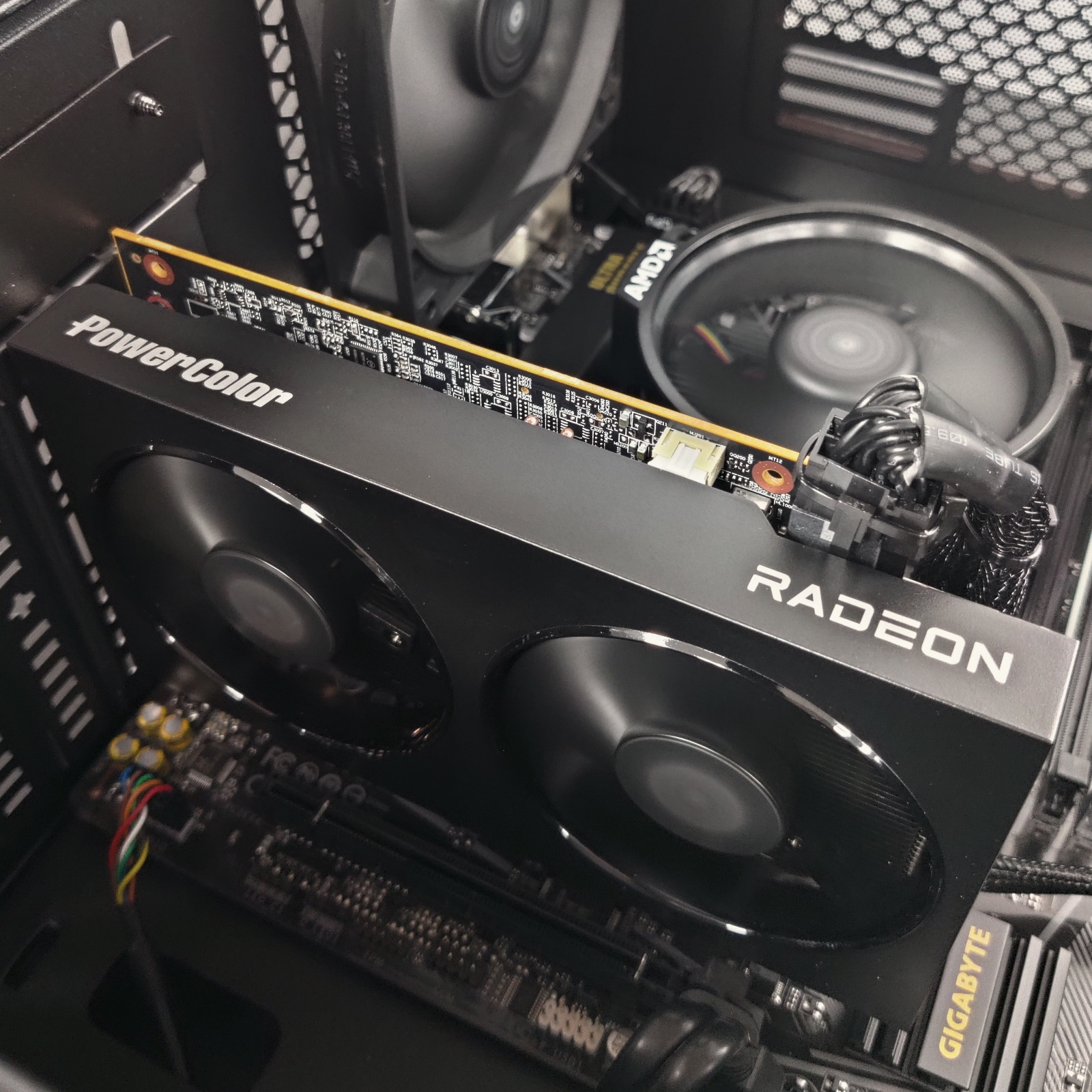 Una tarjeta gráfica PowerColor Radeon negra está instalada en una carcasa de ordenador con ventiladores.