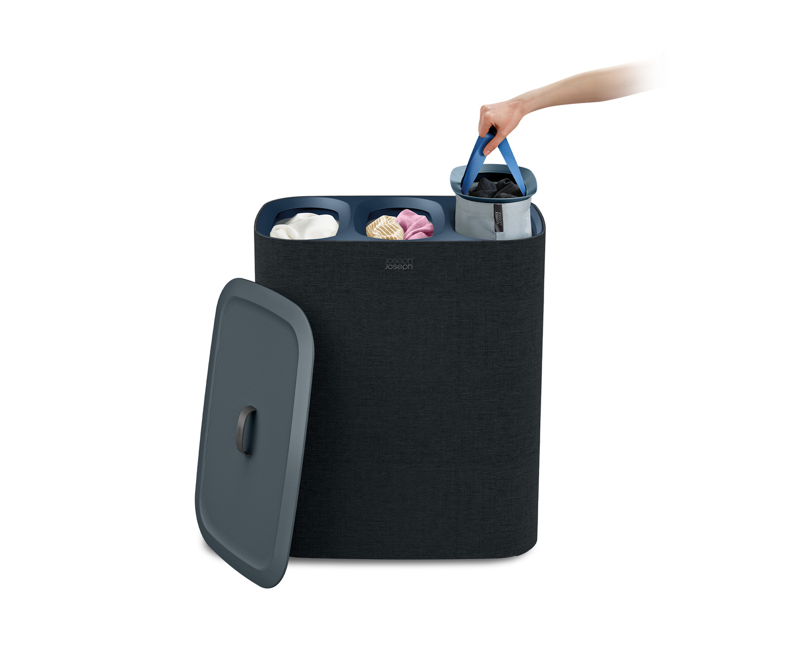 Un clasificador de ropa con tres compartimentos. Una mano levanta un recipiente con ropa oscura. La tapa está abierta.