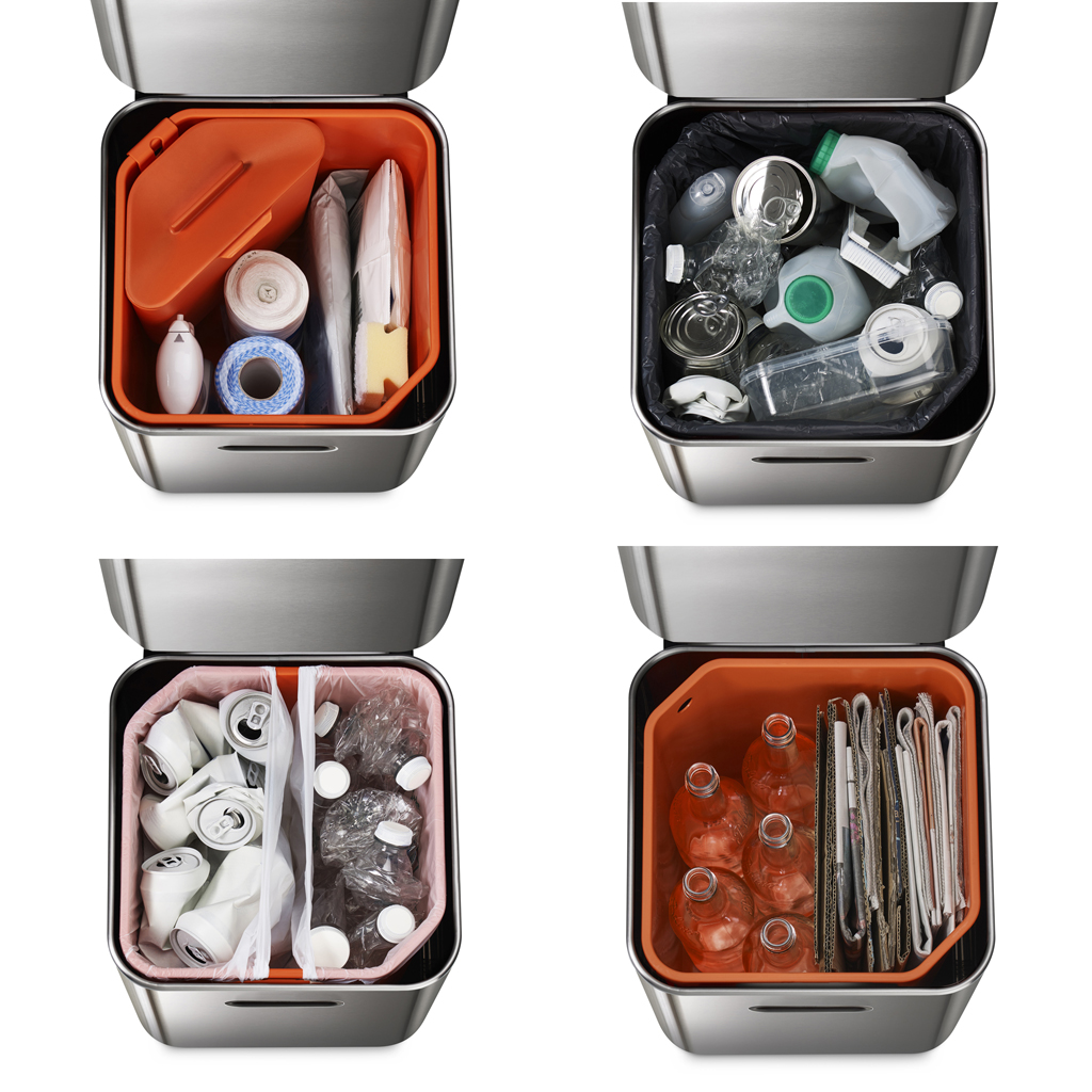 Cuatro botes de basura de acero inoxidable con diferentes contenidos: residuos de alimentos, reciclables, latas y vidrio/papel.