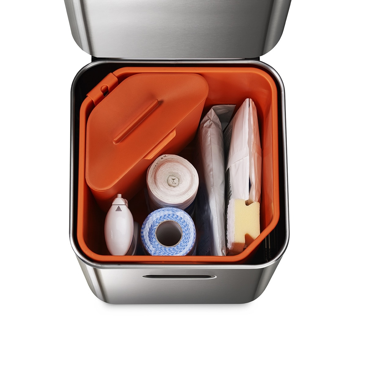 Contenedor de acero inoxidable abierto con interior naranja. Contiene una caja naranja, rollos blancos, un rollo azul y artículos envueltos.