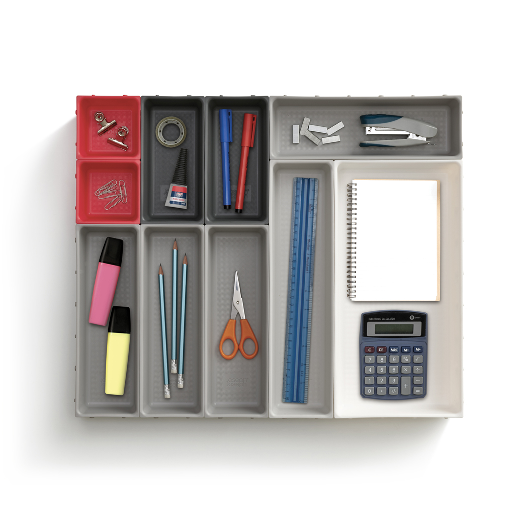 Organizador de escritorio con varios útiles: bolígrafos, lápices, grapadora, tijeras, calculadora, bloc de notas, regla, resaltadores y clips.