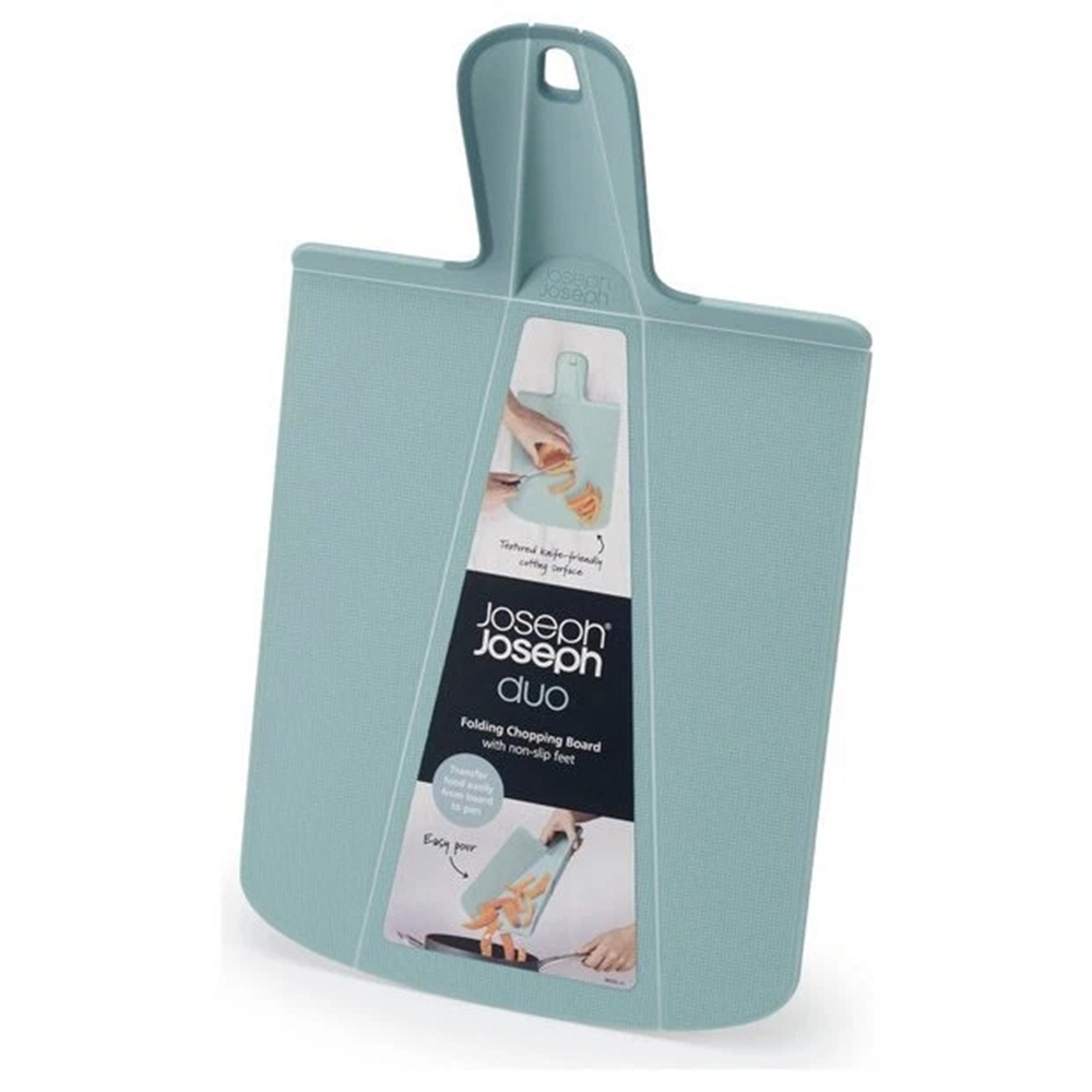 Una tabla de cortar plegable de color verde azulado con asa y una etiqueta que muestra sus características. La etiqueta dice 'Joseph Joseph Duo'.