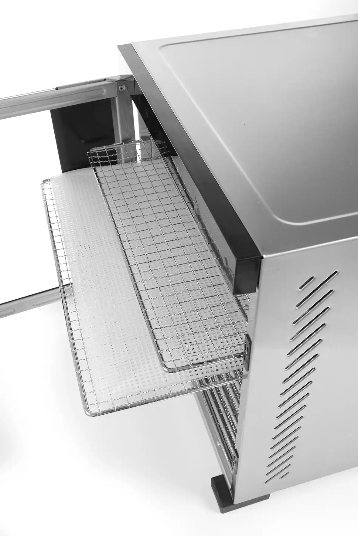Un déshydrateur alimentaire en acier inoxydable est présenté avec des grilles en fil de fer tirées, révélant un plateau blanc. La porte est ouverte et le fond est blanc.