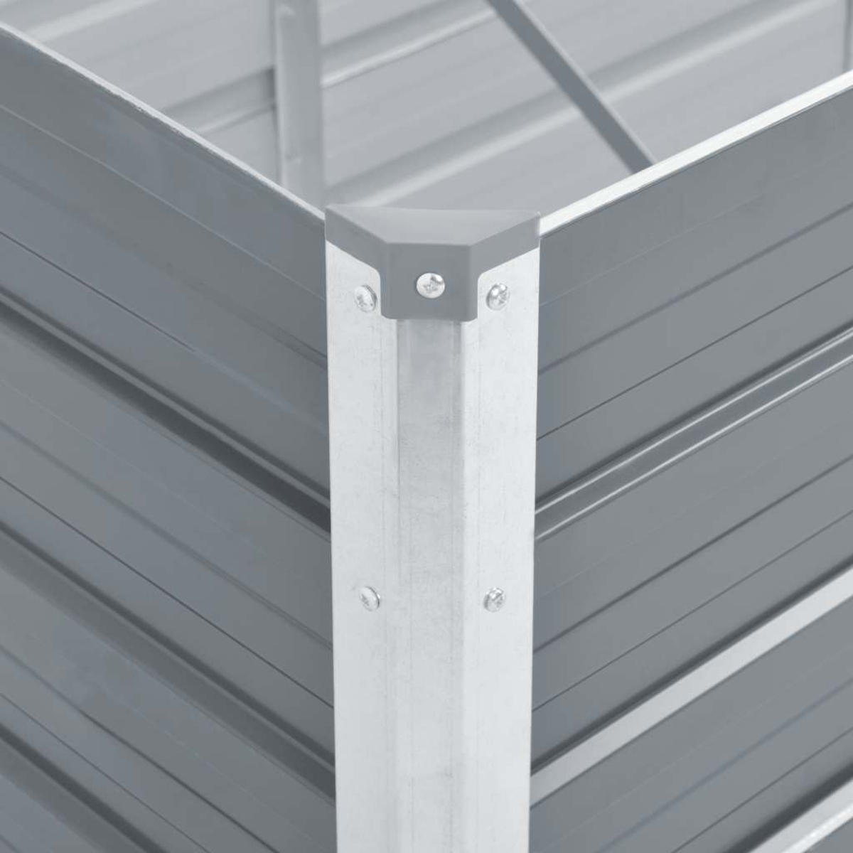 Nahaufnahme einer grauen Metallecke eines Gartenbeets. Der Eckpfosten ist silbern mit grauen Eckkappen und genieteten Paneelen.