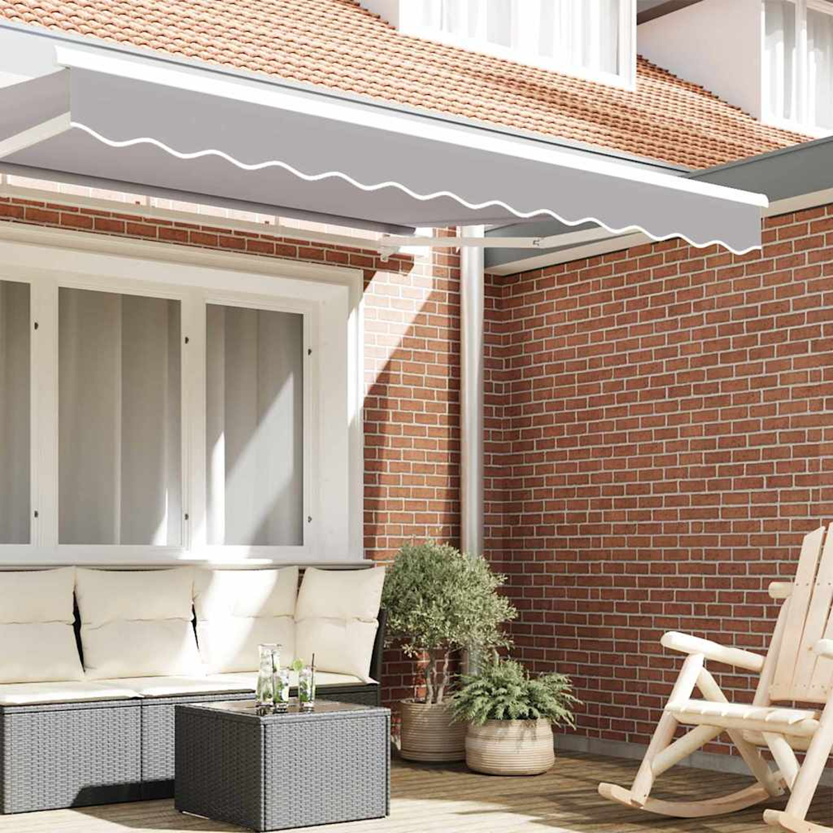 Eine Terrasse mit grauem Baldachin, Backsteinmauer, Sofa, Tisch mit Getränken, Pflanzen in Töpfen und einem Schaukelstuhl.
