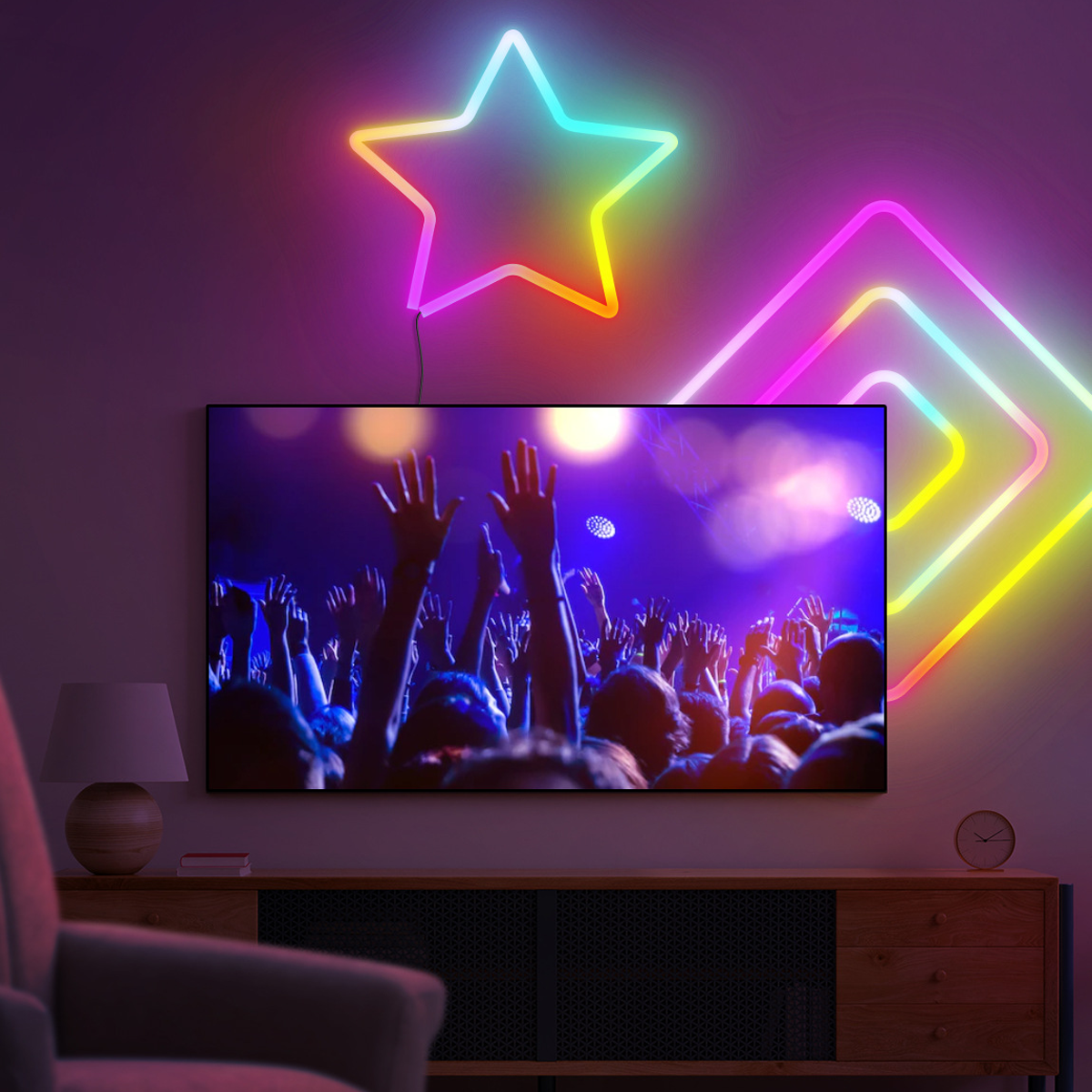 Ein Fernseher zeigt eine Konzertmenge mit erhobenen Händen. Neonsterne und Diamantformen schmücken die Wand darüber. Eine Lampe und ein Schrank sind im Raum.