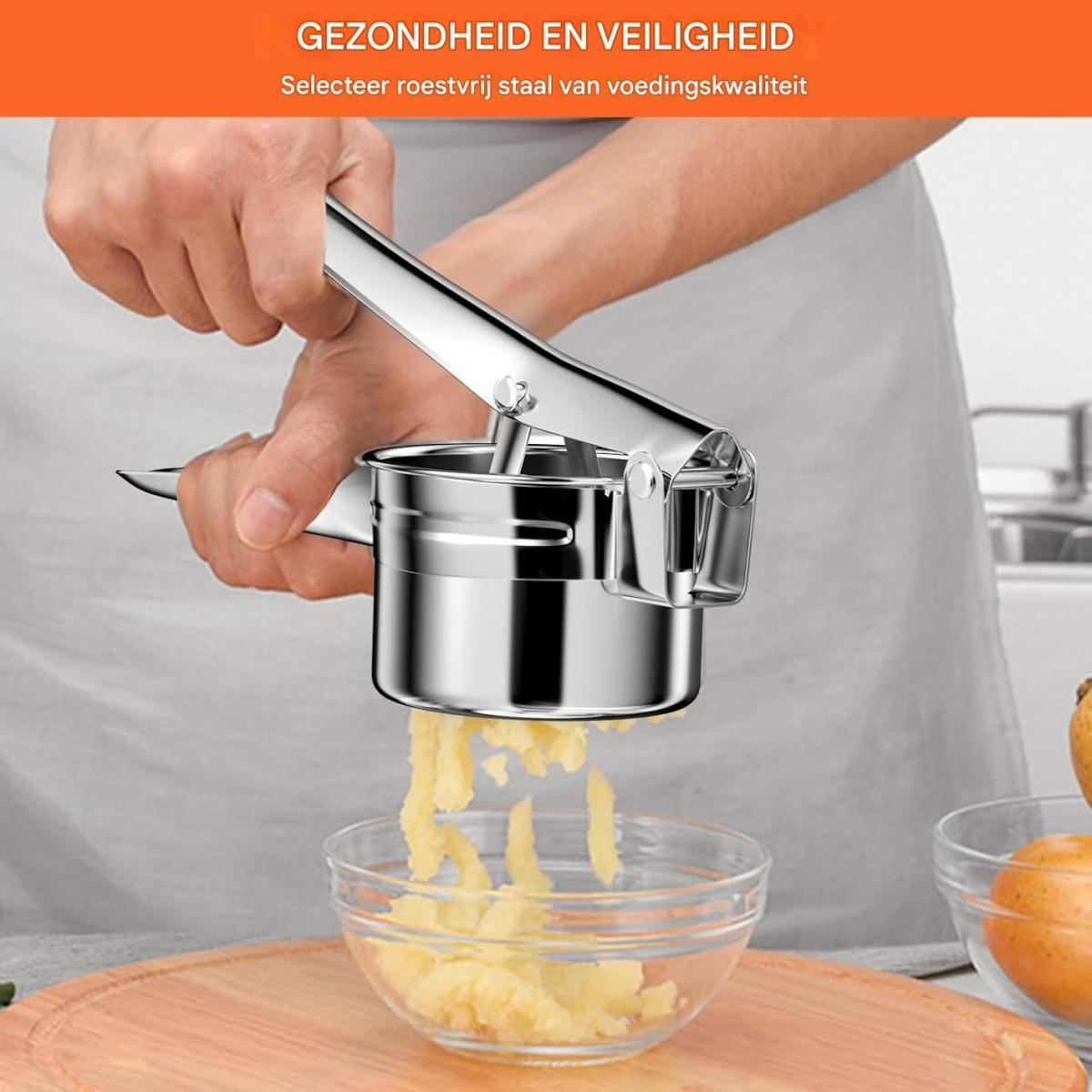 Eine Person drückt eine Kartoffelpresse aus Edelstahl über eine Glasschüssel. Kartoffelpüree fällt in die Schüssel. Oranger Text oben.