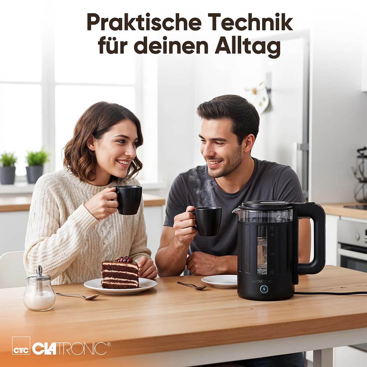 Ein Paar sitzt am Tisch und trinkt aus schwarzen Tassen. Kuchen und ein Wasserkocher sind ebenfalls auf dem Tisch. Werbung für Küchengeräte.