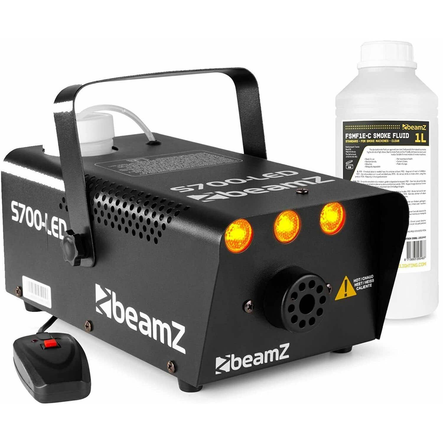Una máquina de humo Beamz 5700-LED negra con control remoto y una botella de líquido de humo. Señal de advertencia al frente.