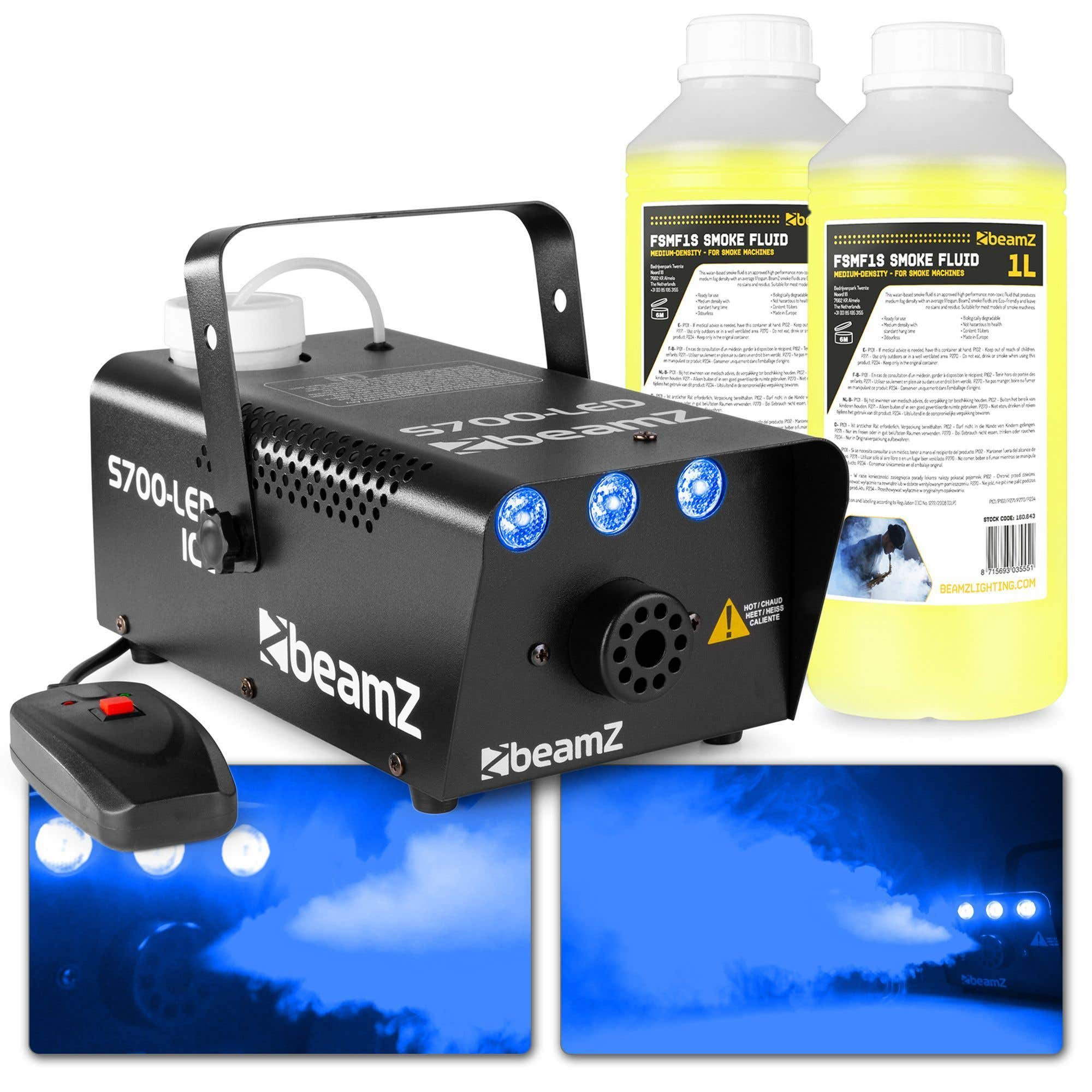 Máquina de humo negra con luces azules y un mando a distancia. Dos botellas de líquido de humo a la derecha.