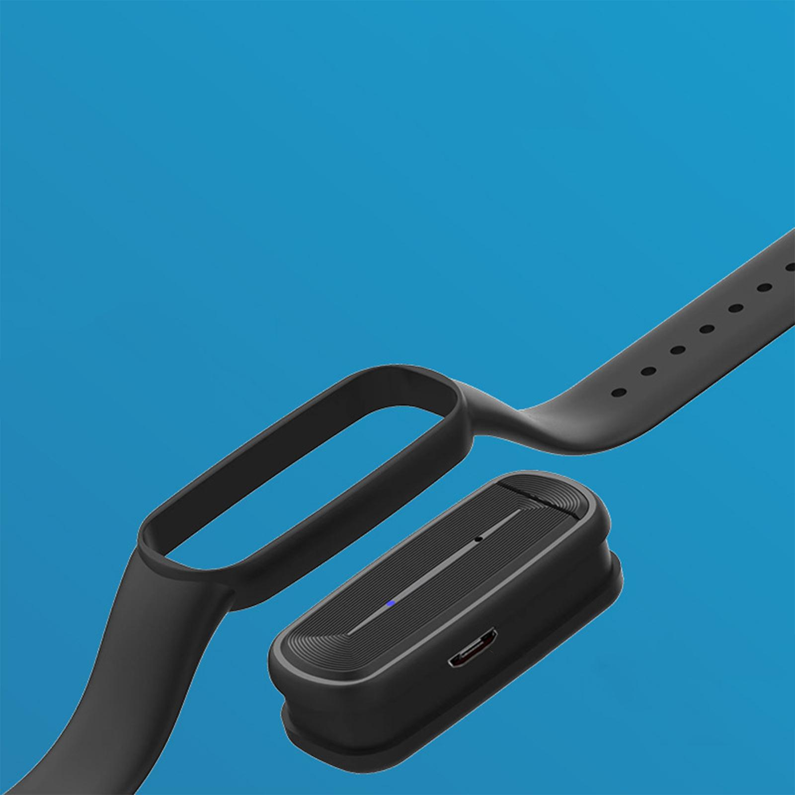 Schwarze Smartwatch-Komponenten vor blauem Hintergrund. Enthält das Armband, einen Ladeanschluss und das Zifferblatt.