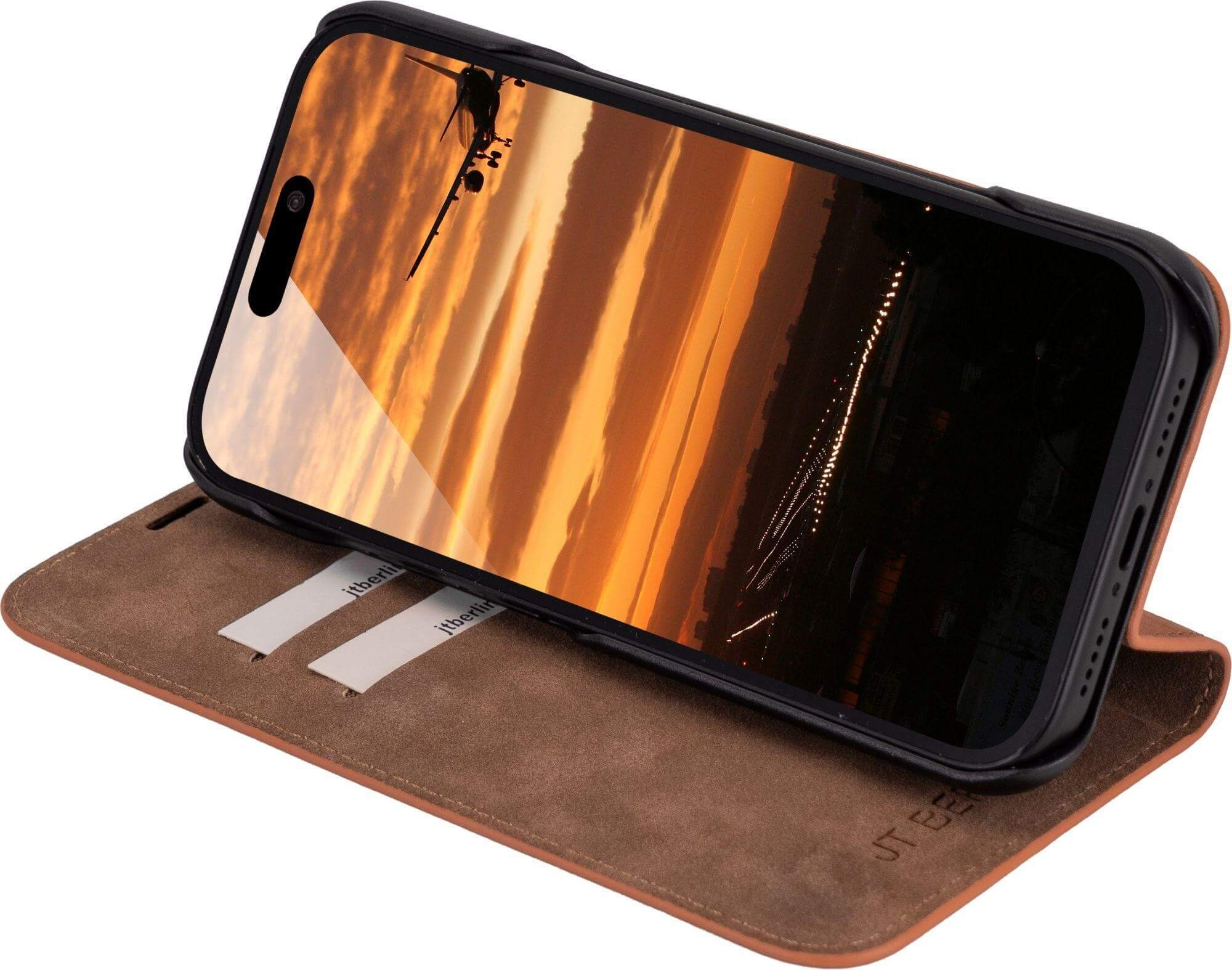 Telefon in Hülle zeigt Sonnenuntergang. Hülle ist braun, offen. Telefon ist schwarz.