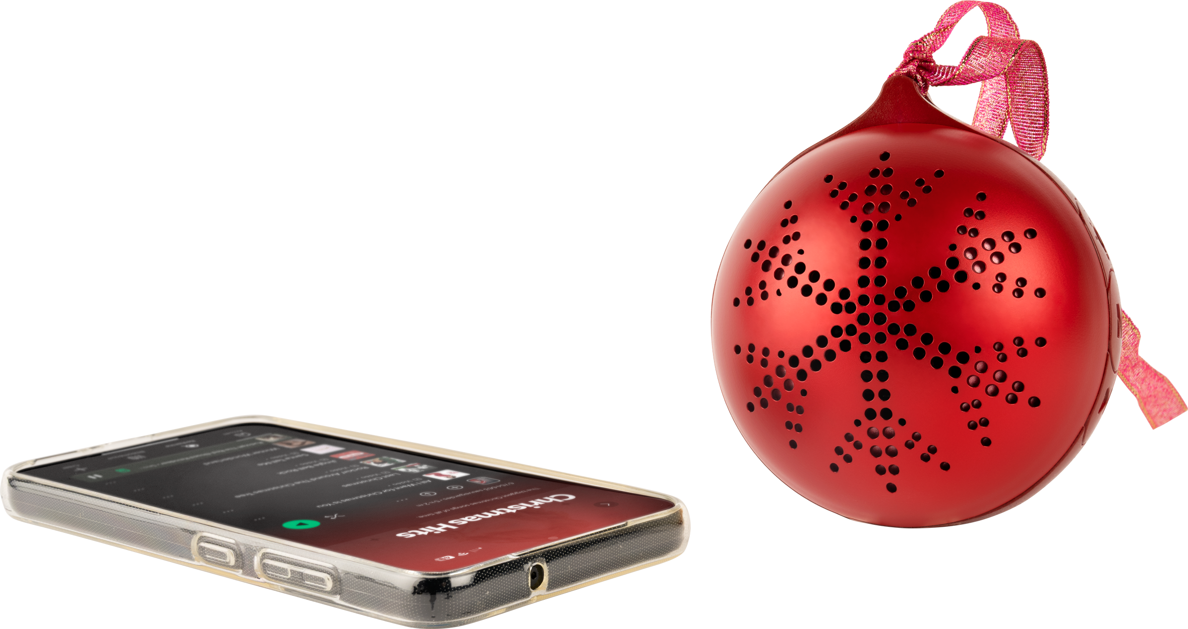 Ein roter Weihnachtsschmuck mit Schneeflockenmuster und ein Telefon, das Weihnachtsmusik abspielt.