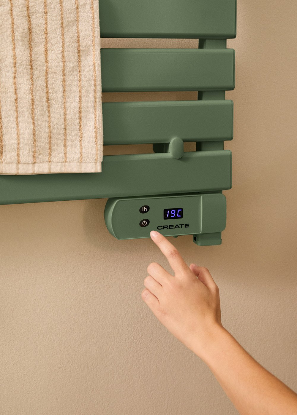 Mano tocando una pantalla digital en un toallero verde. La pantalla muestra la temperatura. Una toalla cuelga del estante.