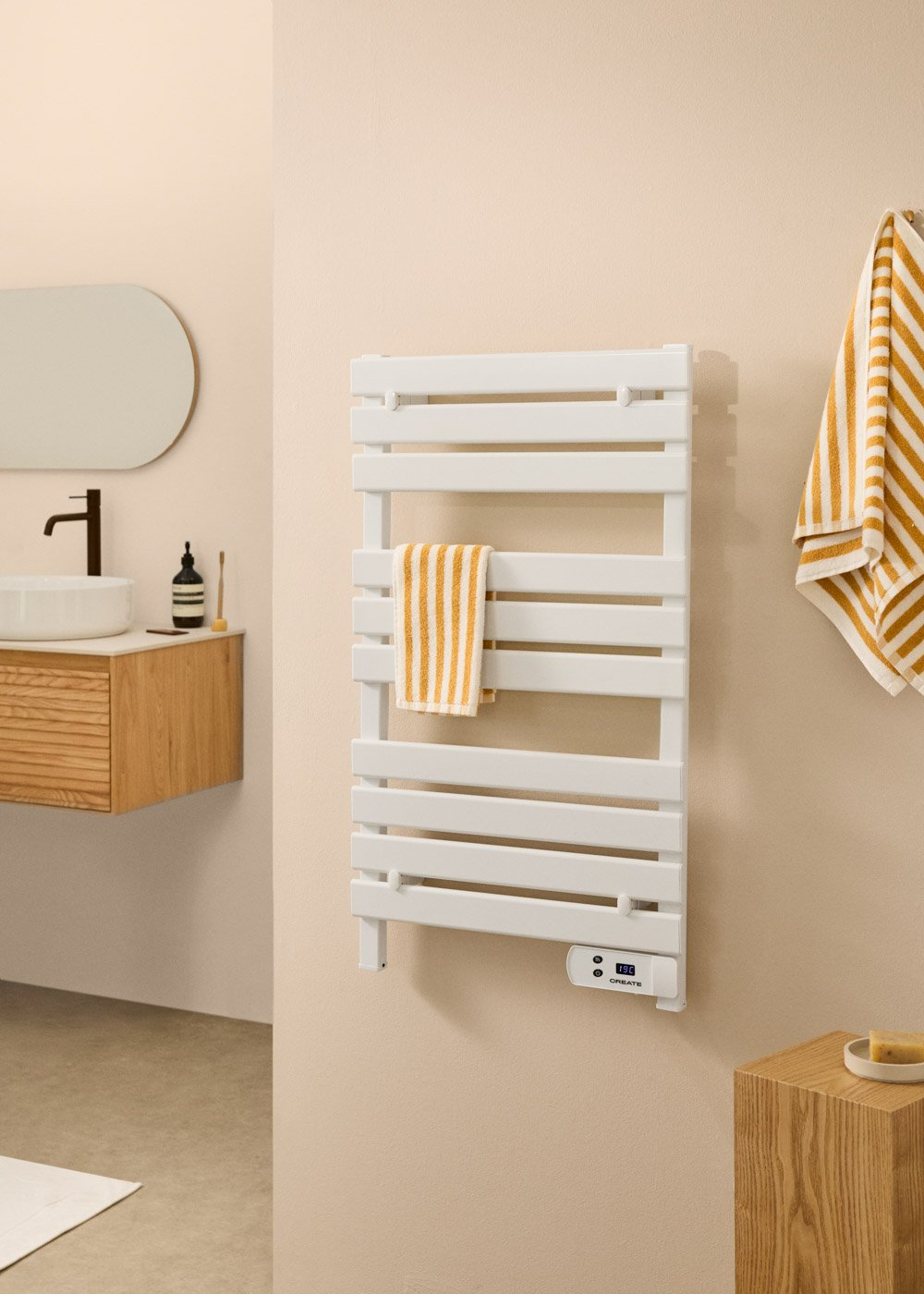 Un baño moderno con un calentador de toallas blanco, toallas y un mueble de madera con lavabo y espejo.