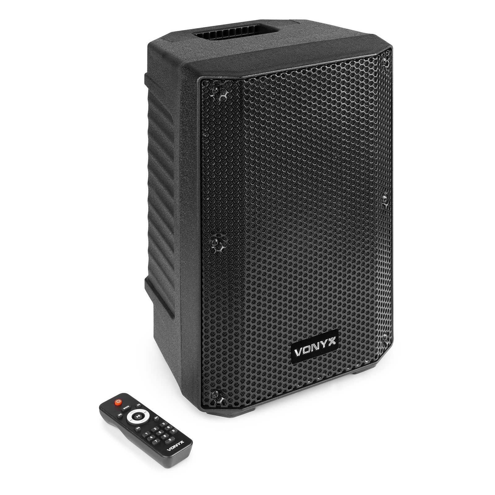 Altavoz Vonyx negro con mando a distancia sobre fondo blanco. El altavoz tiene una rejilla frontal y un logotipo.