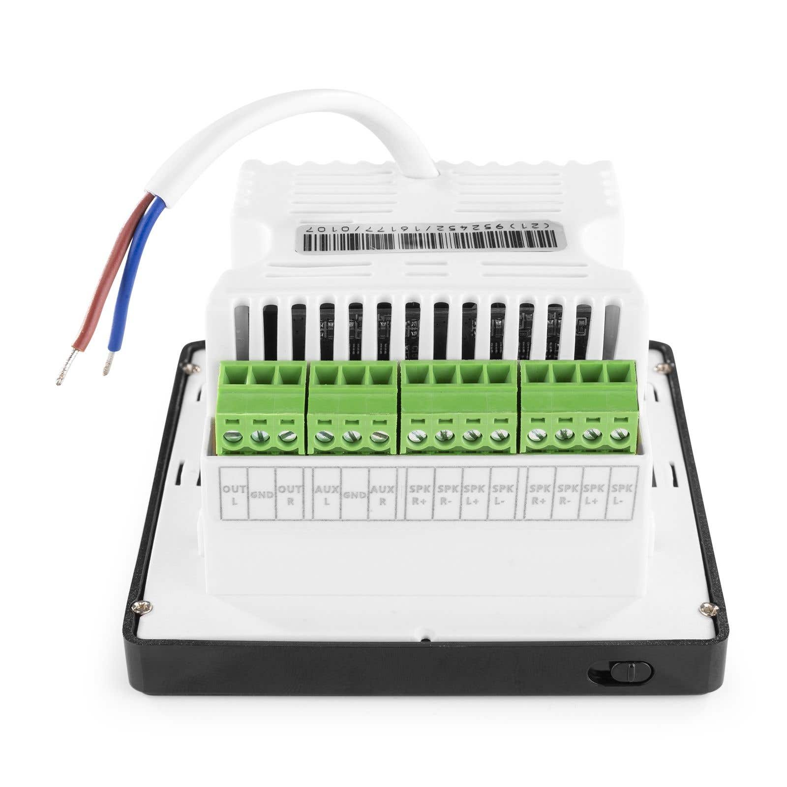 Dispositivo electrónico con terminales verdes, cable blanco y cables. Las etiquetas incluyen OUT, AUX, SPK. Carcasa negra y blanca.