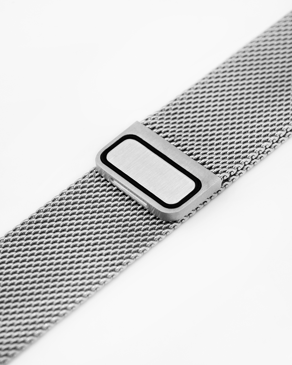Nahaufnahme eines silbernen Uhrenarmbands. Das Armband hat ein Mesh-Design und der Verschluss ist rechteckig mit schwarzem Rand.